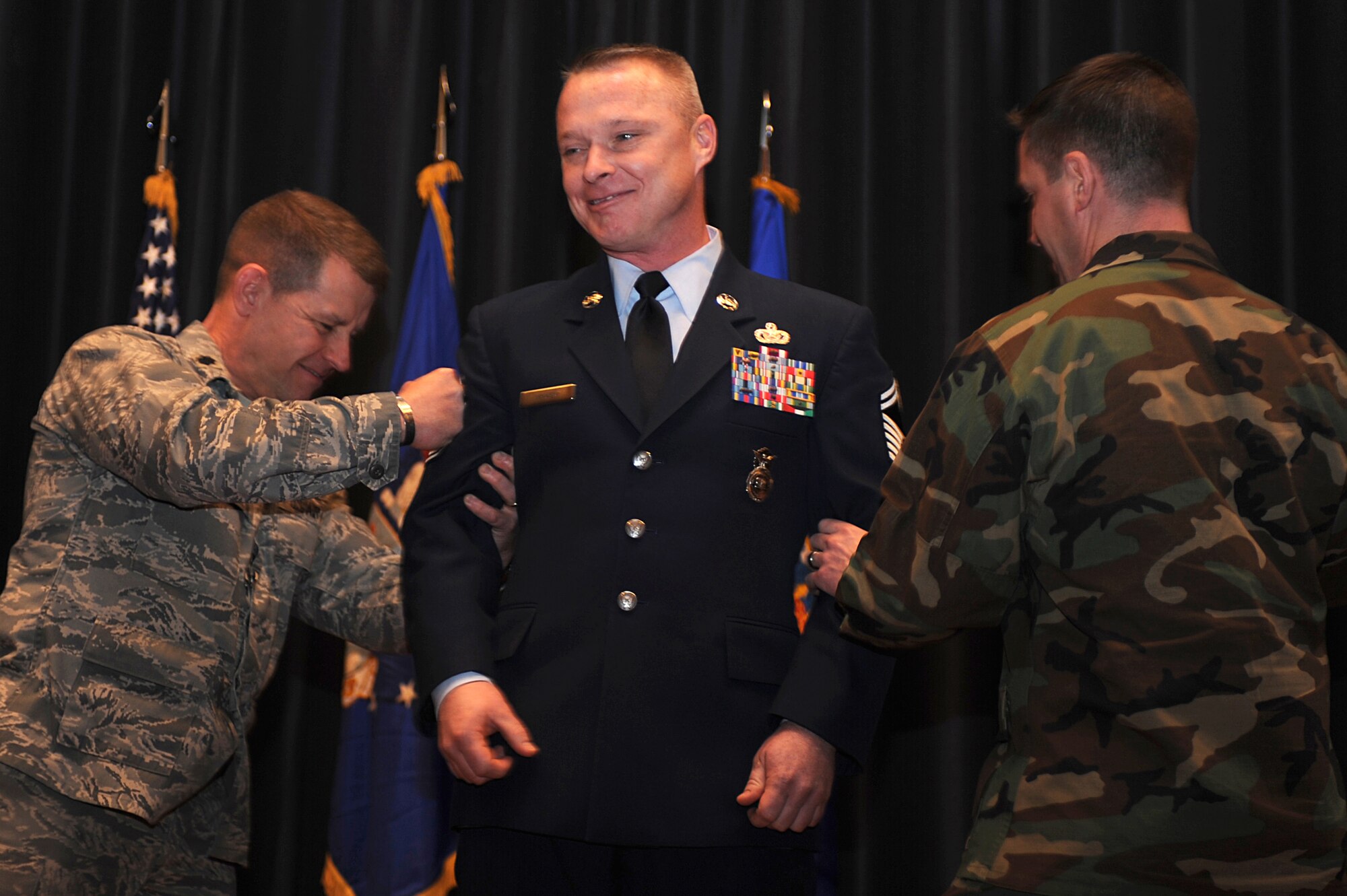 Senior Master Sgt. Scott Pepper, 421st Combat Training Squadron superintendent, gets his newly promoted senior stripes tacked on by Lt. Col. Mitchell Monroe, 421st CTS commander, and Lt. Col. Matthew Lacy, 421st CTS director of operations, during the U.S Air Force Expeditionary Center promotion ceremony Jan. 8, 2009, on Fort Dix, N.J. Sergeant Pepper's effective date of promotion was Jan. 1.  (U.S. Air Force Photo/Staff Sgt. Nathan Bevier)