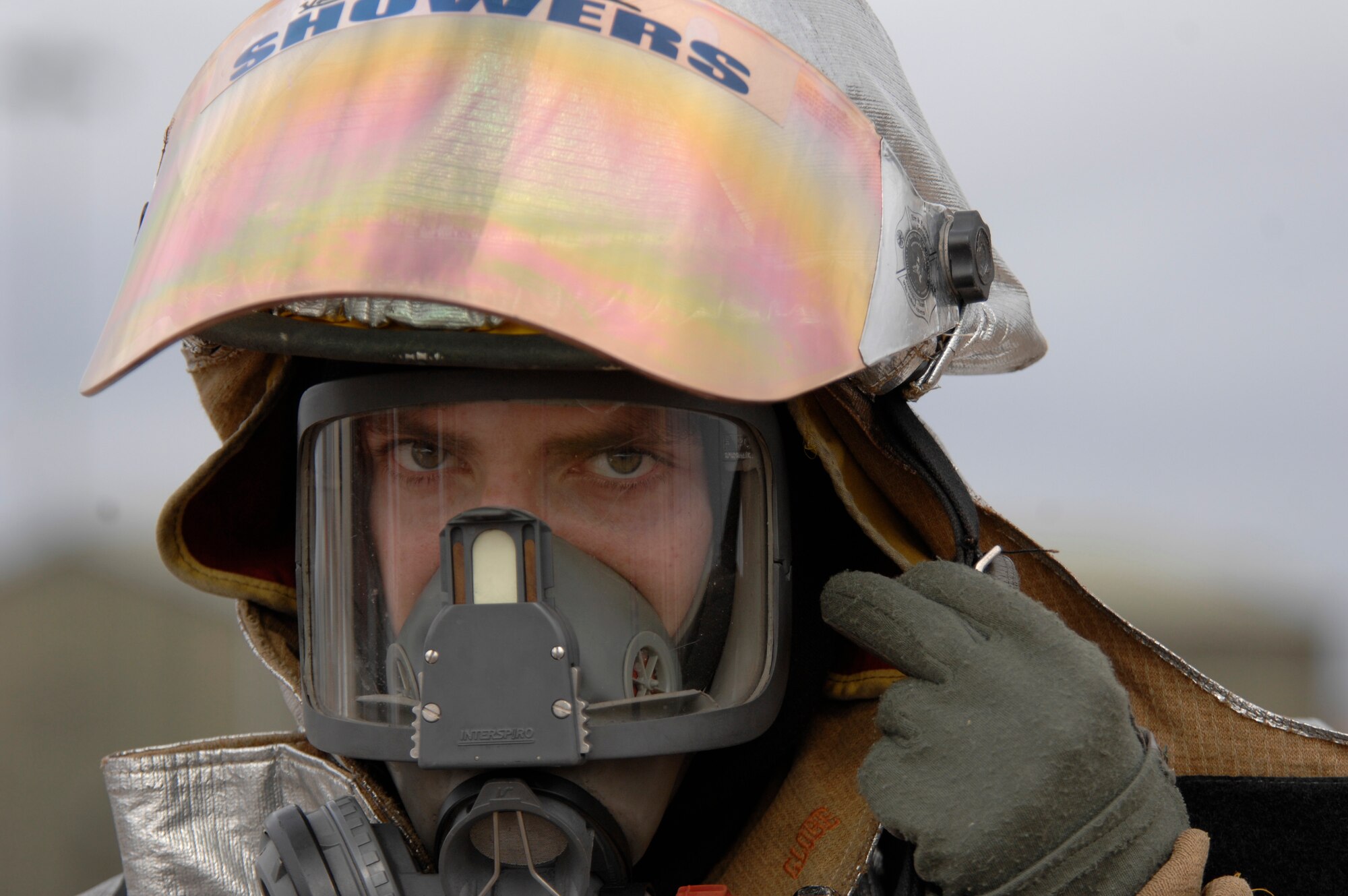 Staff Sgt. Nathan Showers 48th Civil Engineer Squadron firefighter attaches his helmet, March 8 at RAF Mildenhall, England. Firefighters from 48th Civil Engineer Squadron, and 100th Civil Engineer Squadron participated in simulated fires in a cargo plane. (U.S. Air Force photo by Airman Perry Aston)
