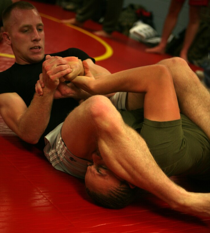 Cpl. Nick Vana, an ammunition technician from School Of Infantry East aboard Camp Geiger, N.C., places Pfc. Melissa Rodriguez, a supply clerk from Combat Logistics Regiment 2, 2nd Marine Logistics Group, into an arm bar joint lock, here, Jan. 21.  Rodriguez and Vana are memebers of a Jiu Jitsu team put together by Staff Sgt. Adam R. O'Malley, a four-year Marine Corps Martial Arts Program instructor from CLR-2 and Sgt. Christopher Siburt, a mechanic from General Support Motor Transport Company, CLR-2.