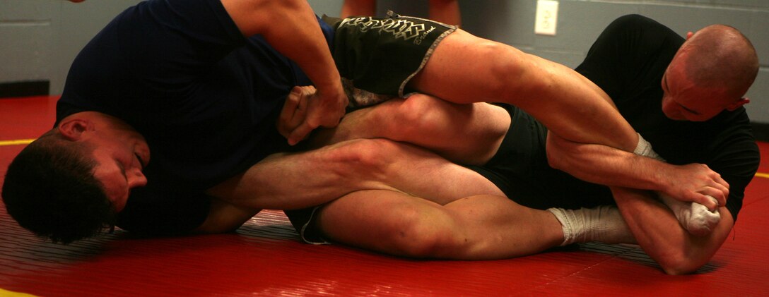 Staff Sgt. Adam R. O'Malley, a Marine Corps Martial Arts Program instructor from Combat Logistics Regiment 2, 2nd Marine Logistics Group, and Sgt. Christopher Siburt, a mechanic from General Support Motor Transport Company, CLR-2, show that size isn't a factor while they display a tough grappling match during practice, here, Jan. 21. O'Malley and Siburt recently took their passion for MCMAP and all mixed martial arts to a new level by starting a Jiu Jitsu team within the logistics group.
