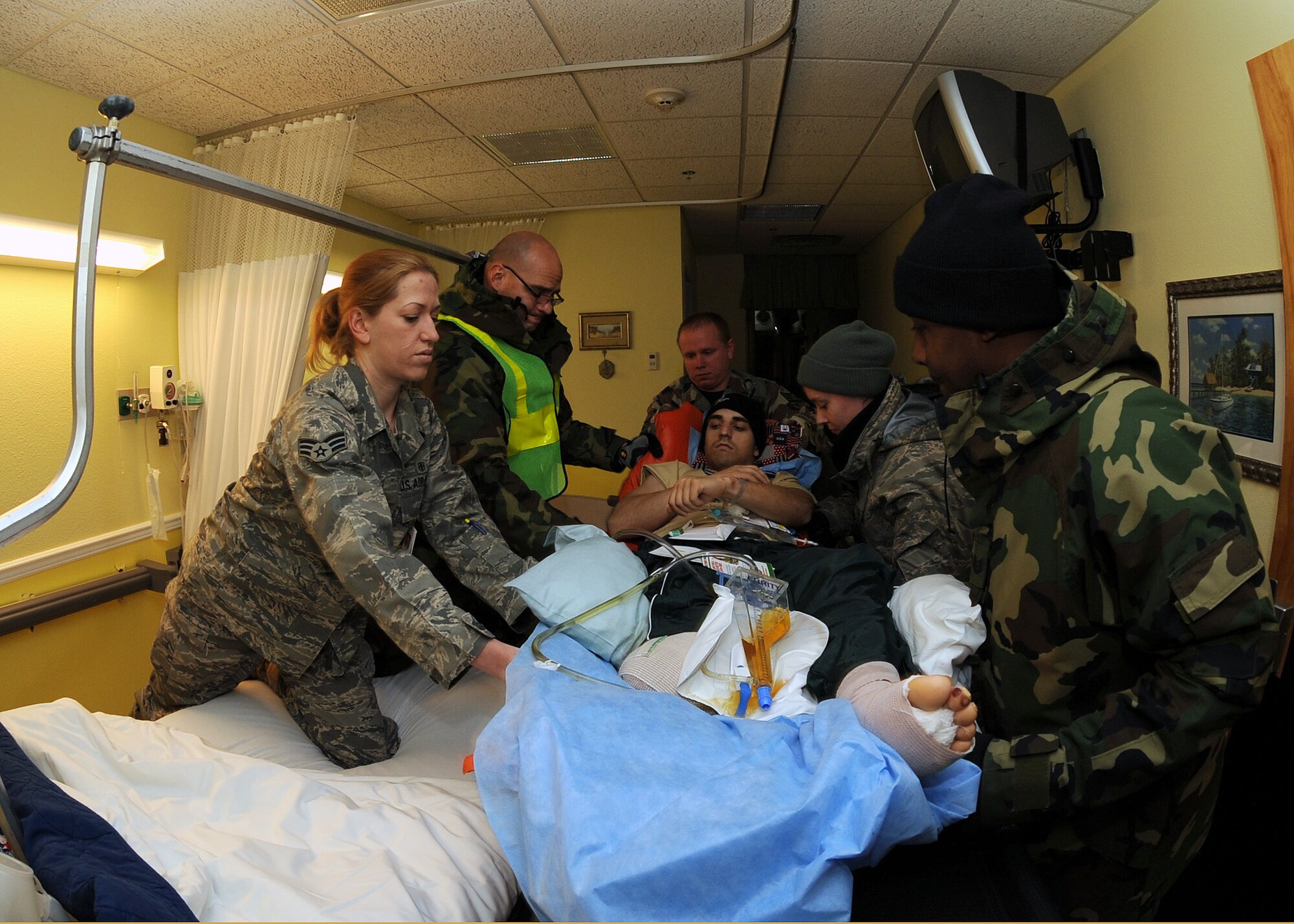 SCOTT AIR FORCE BASE, Ill. -- Volunteers and members of the 375th Aeromedical Staging Facility transfer Army Pfc. Andrew Bradley, an infantryman from the 82nd Airborne unit from Fort Bragg, N.C., from his gurney to his hospital bed inside Scott’s staging facility. Private Bradley lost his right foot in an improvised explosive device blast. He was one of many wounded warriors to land at Scott throughout the weekend. (U.S. Air Force photo/Airman 1st Class Wesley Farnsworth)