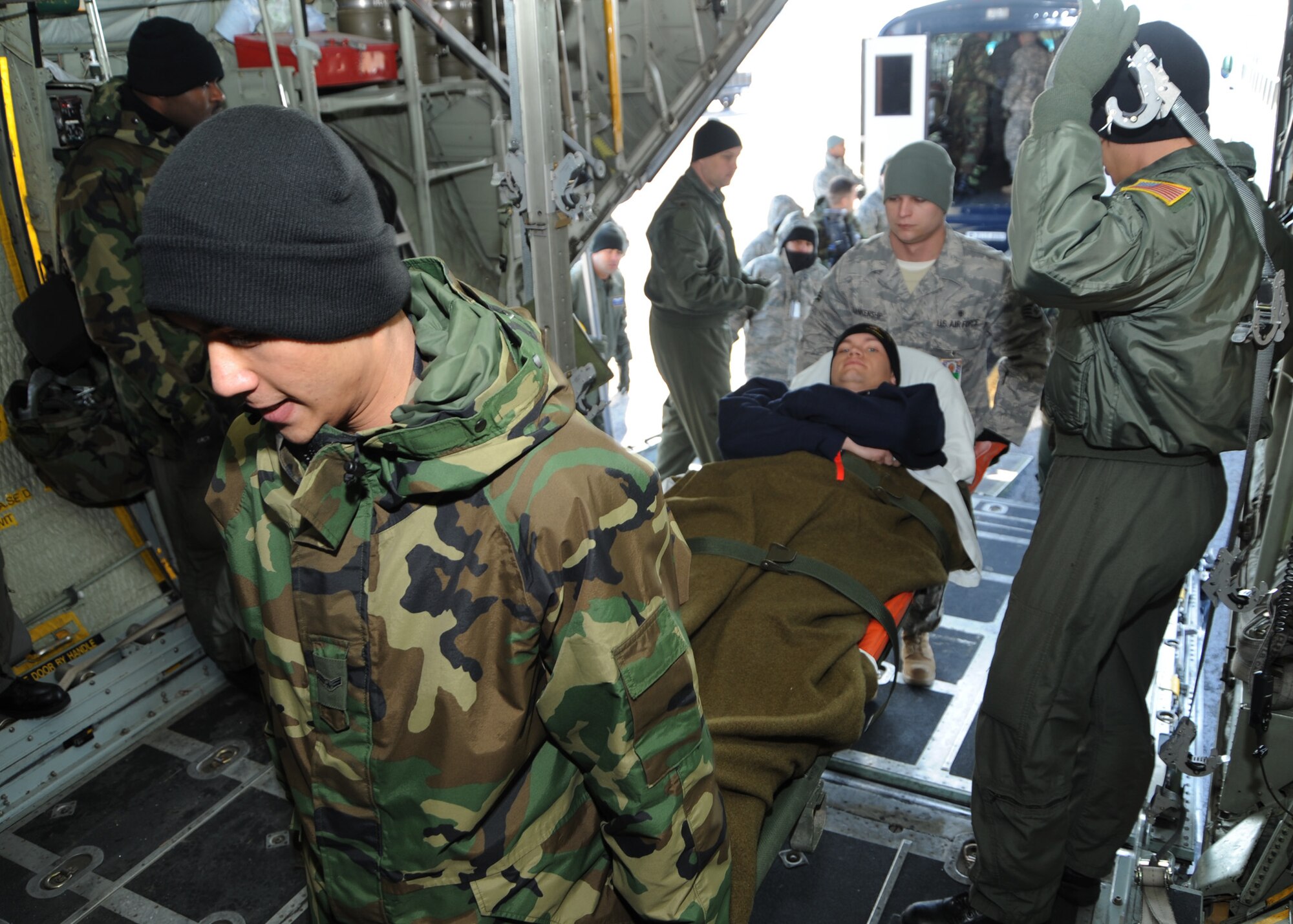 SCOTT AIR FORCE BASE, Ill. -- Airman 1st Class Eliezer Kalingo and Staff Sgt. Matthew Blankenship, 375th Medical Group Aeromedical Staging Facility medical technicians, carry Army Pfc. Brandon Roodhouse onto a plane at Scott in preparation for his flight home Saturday. (U.S. Air Force photo/Airman 1st Class Wesley Farnsworth)