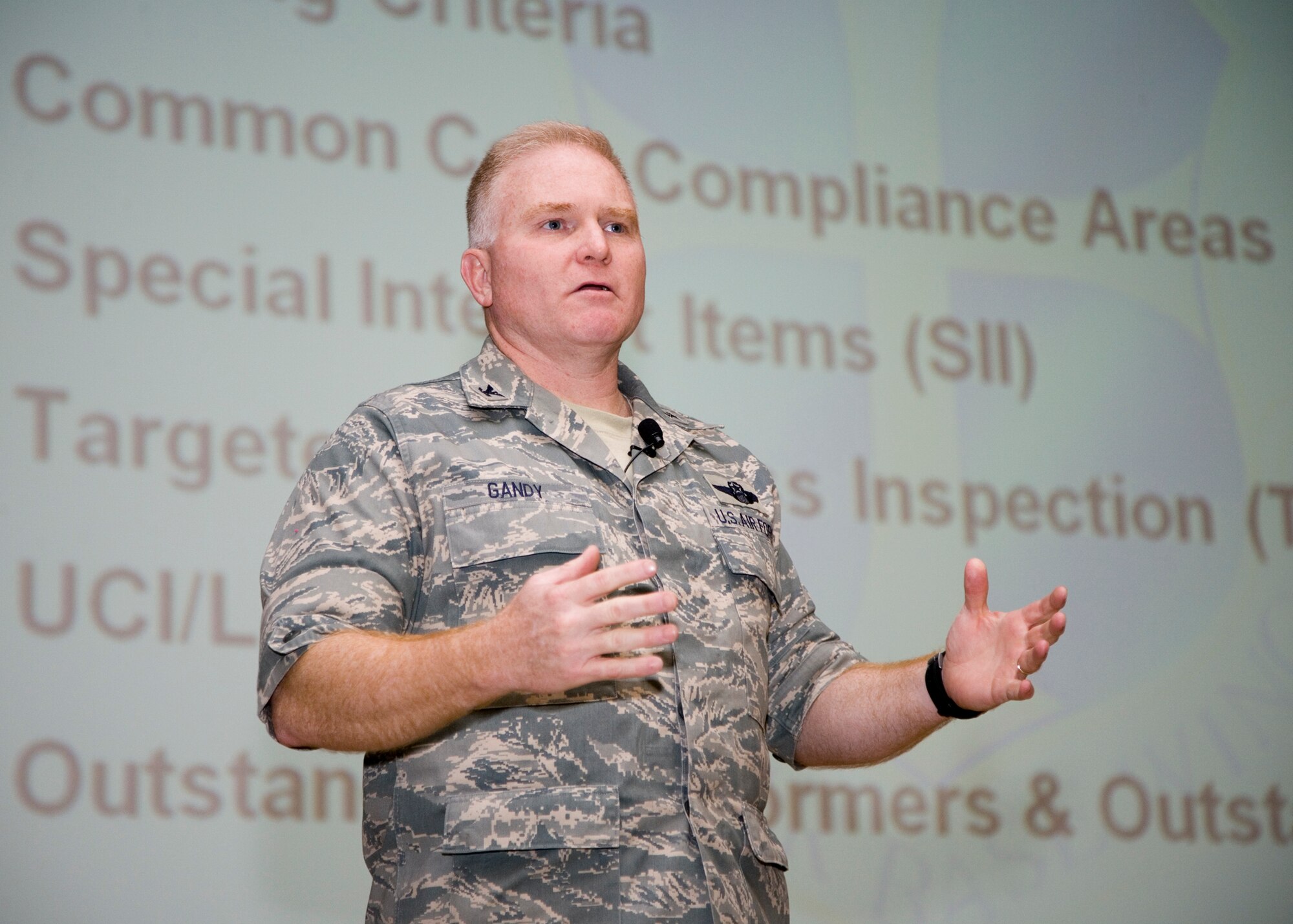 Col. Jerry Gandy, 95th Air Base Wing commander, talks to Wing personnel during the Unit Compliance Inspection outbrief at the base theater Jan. 20. The Air Force Flight Test Center received an "Excellent" grade for the UCI and a "Satisfactory" grade for the Logistics Standardization and Evaluation Team inspection. (Air Force photo by Bobbi Zapka)