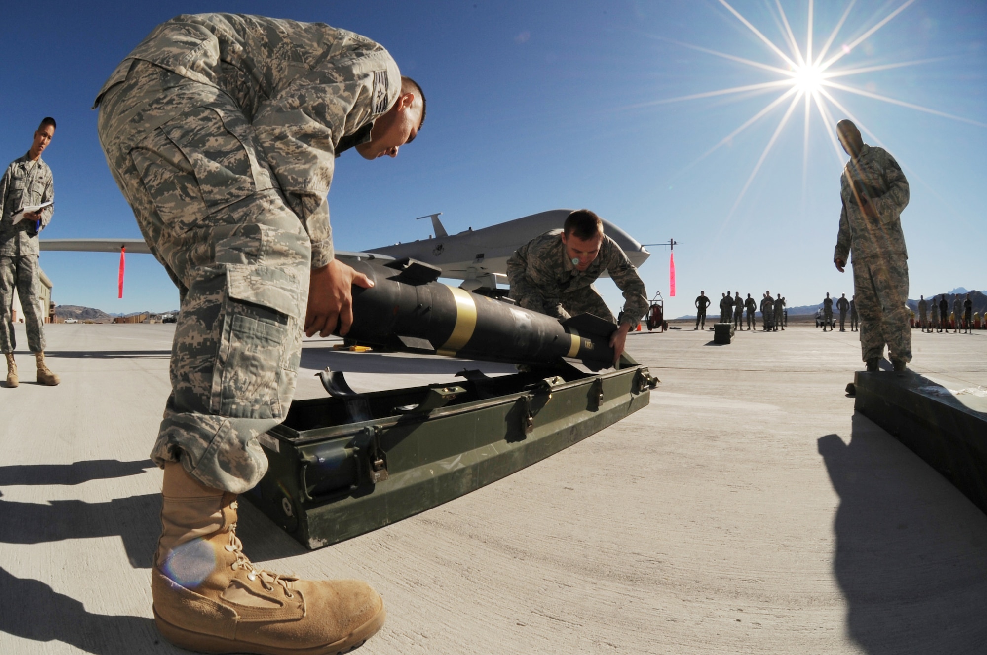 CREECH AFB, Nev. -- Staff Sgt. Bobby Domanski, 432d Aircraft Maintenance Squadron and Airman 1st Class Aaron Weddington, 432d Maintenance Squadron, remove a Hellfire missile in preparation for loading the weapon onto a MQ-1B Predator during the 432d Wing weapons load crew competition here Jan. 16th. This was the first weapons load competition since the 432d Wing was activated at Creech in May 2007. (U.S. Air Force photo/Senior Airman Brian Ybarbo)