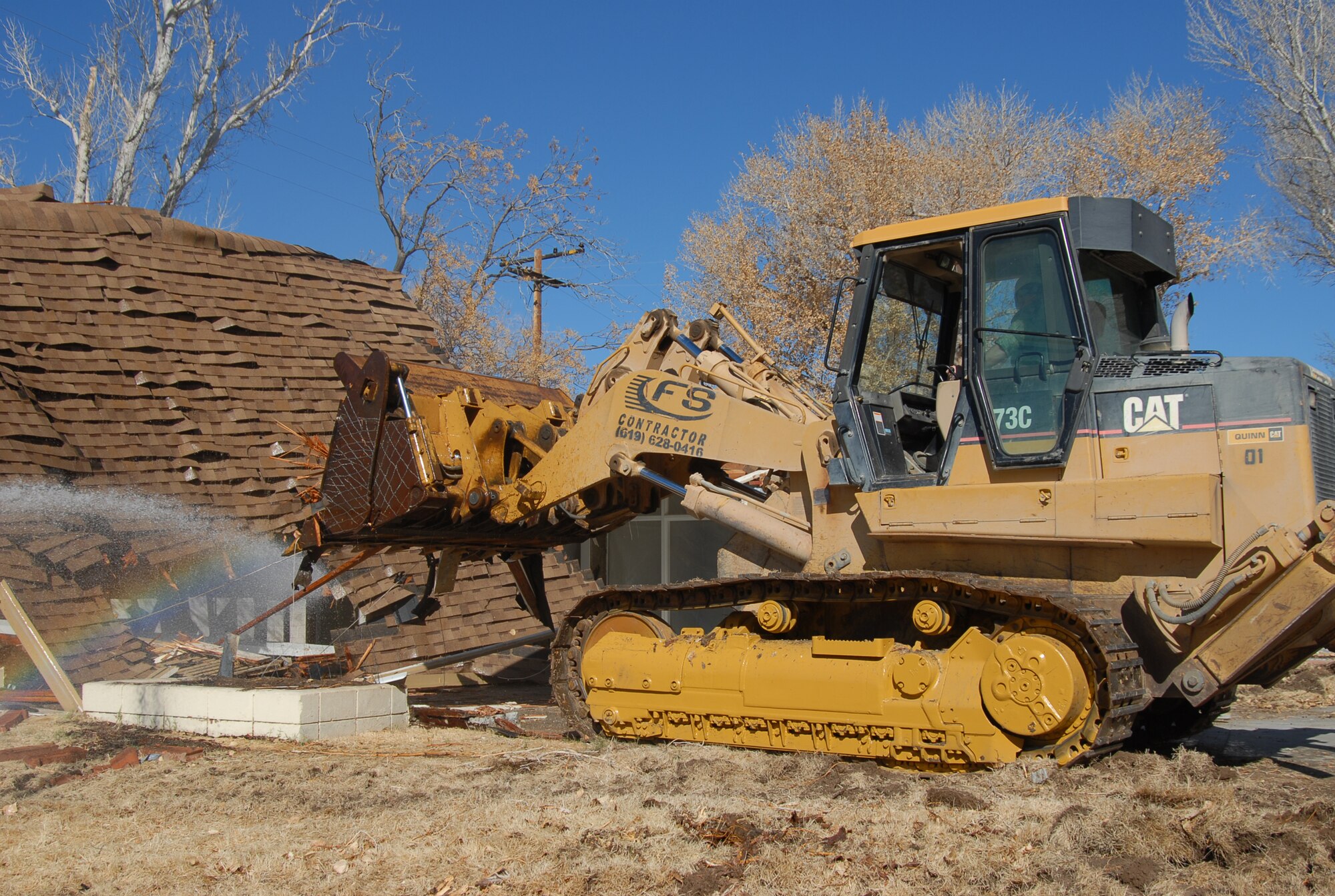 Col. Jerry Gandy, 95th Air Base Wing commander, demolishes a house at the Palo Verde Housing district Jan. 20 to begin construction in the area. (Air Force photo by Senior Airman Julius Delos Reyes)
