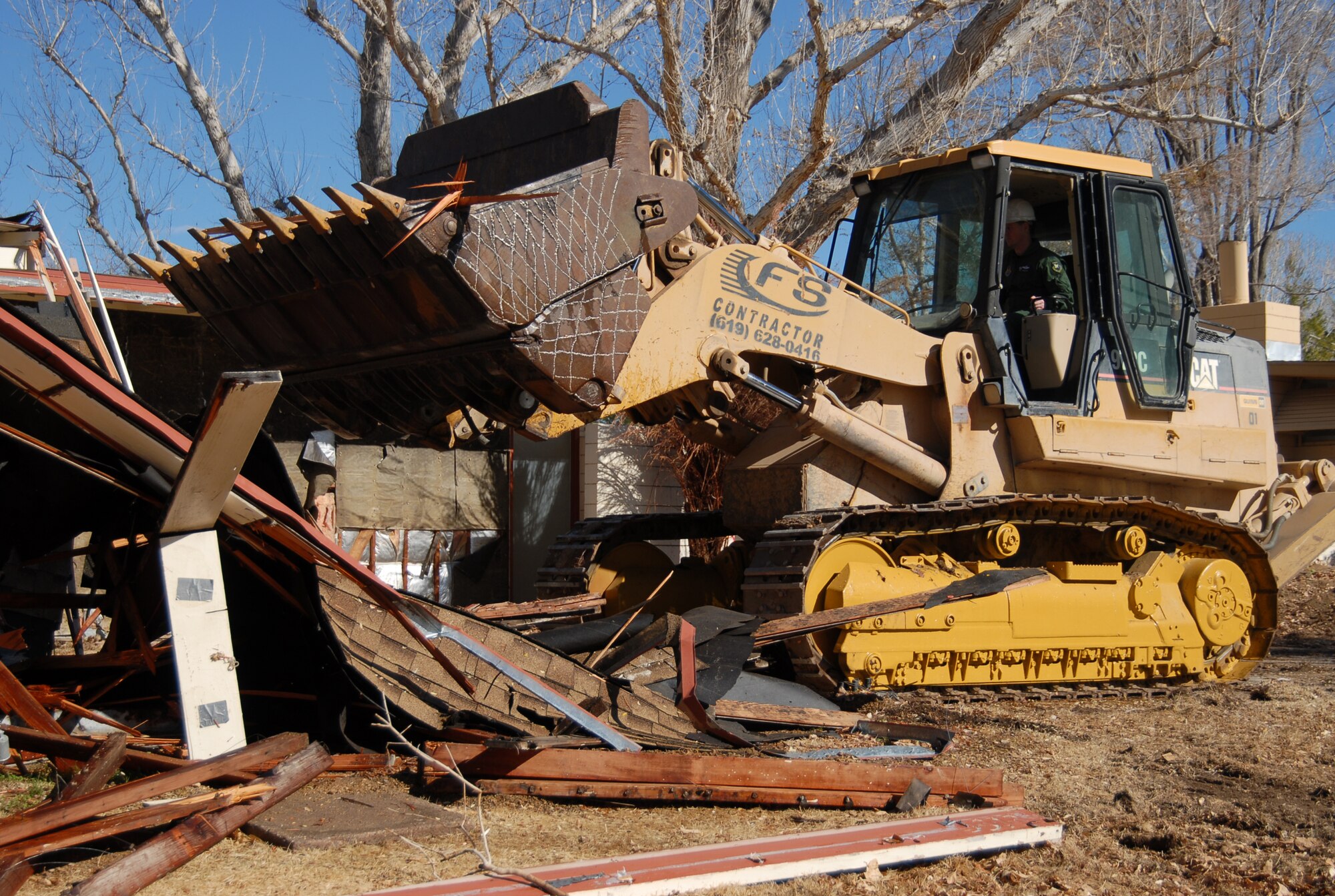 Col. William Thornton, 412th Test Wing commander, demolishes a house at the Palo Verde Housing district Jan. 20 to begin construction in the area. (Air Force photo by Senior Airman Julius Delos Reyes)