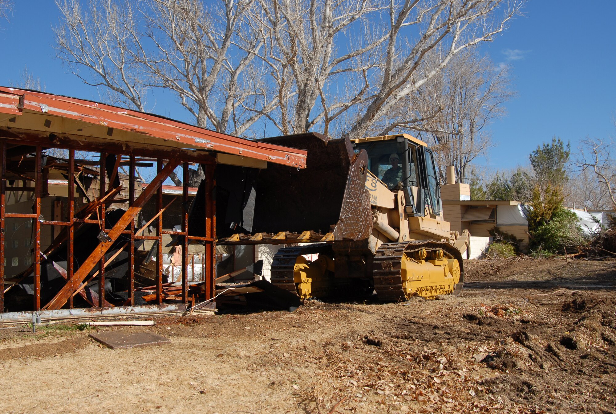 Maj. Gen. David Eichhorn, Air Force Flight Test Center commander, demolishes a house at the Palo Verde Housing district Jan. 20 to begin construction in the area. (Air Force photo by Senior Airman Julius Delos Reyes)