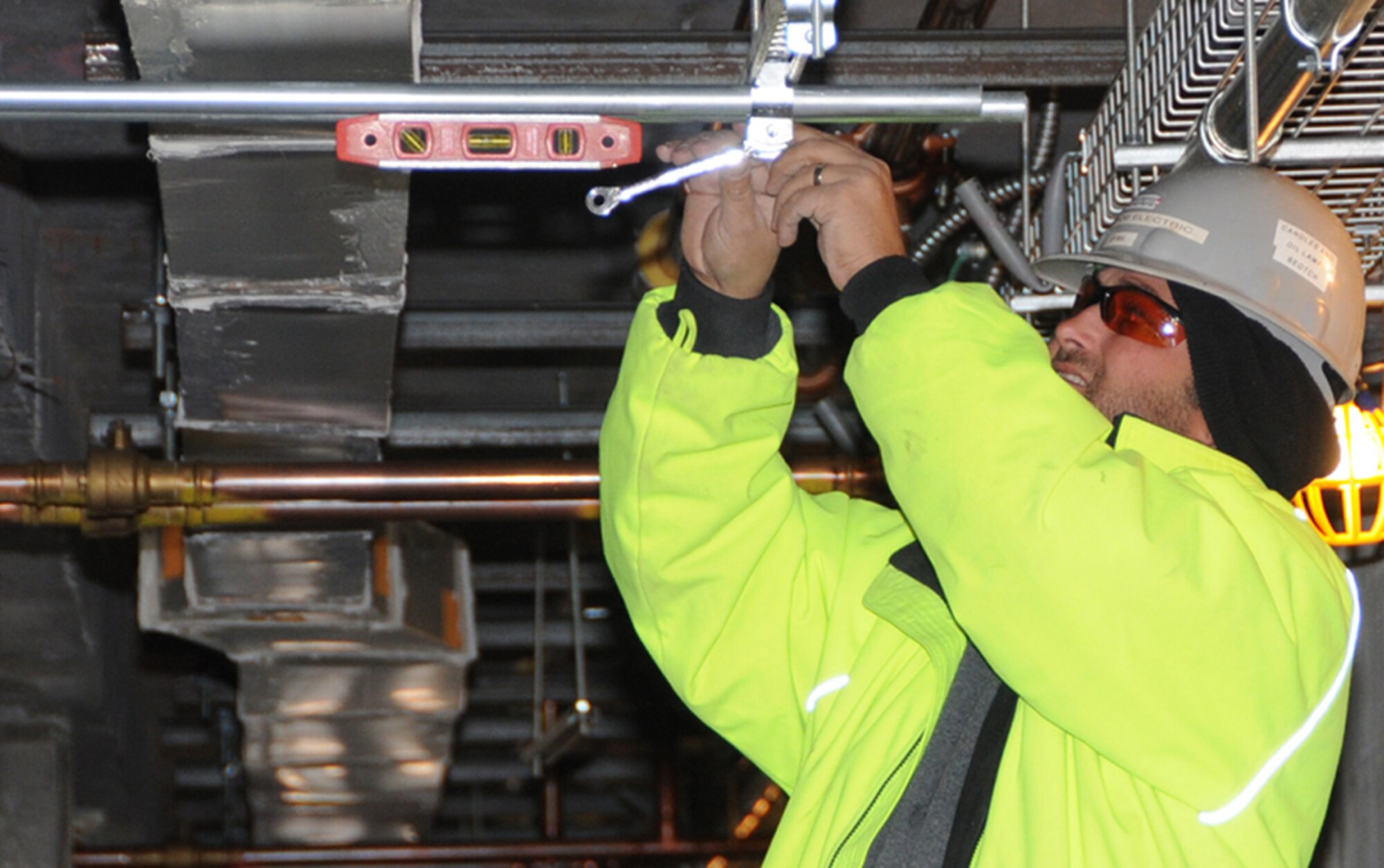 Electrician Jeff Breal hangs conduit on the dorm’s second floor.  (U.S. Air Force photo by Kemberly Groue)
