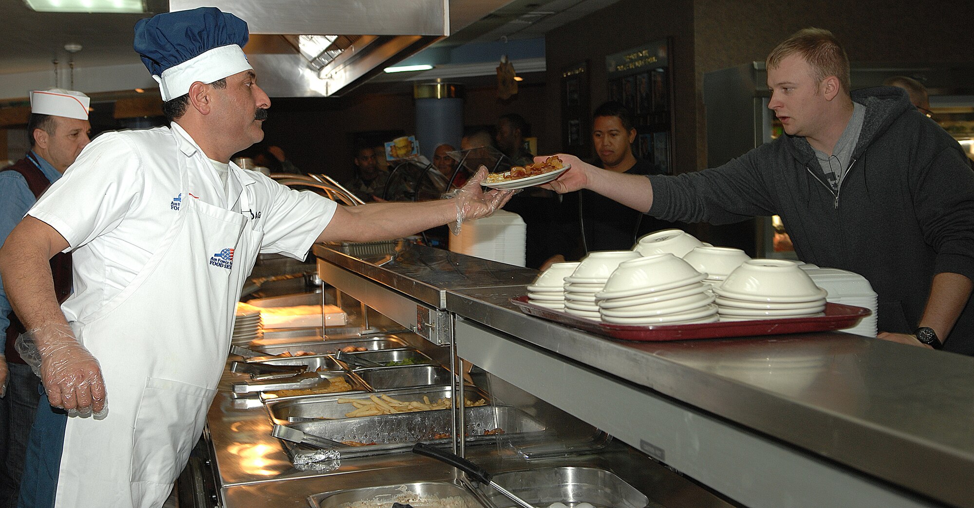 An Incirlik Sultan's Inn personnel serves one of the first meals to a Team Incirlik member at approximately 10:30 p.m., Jan. 21.