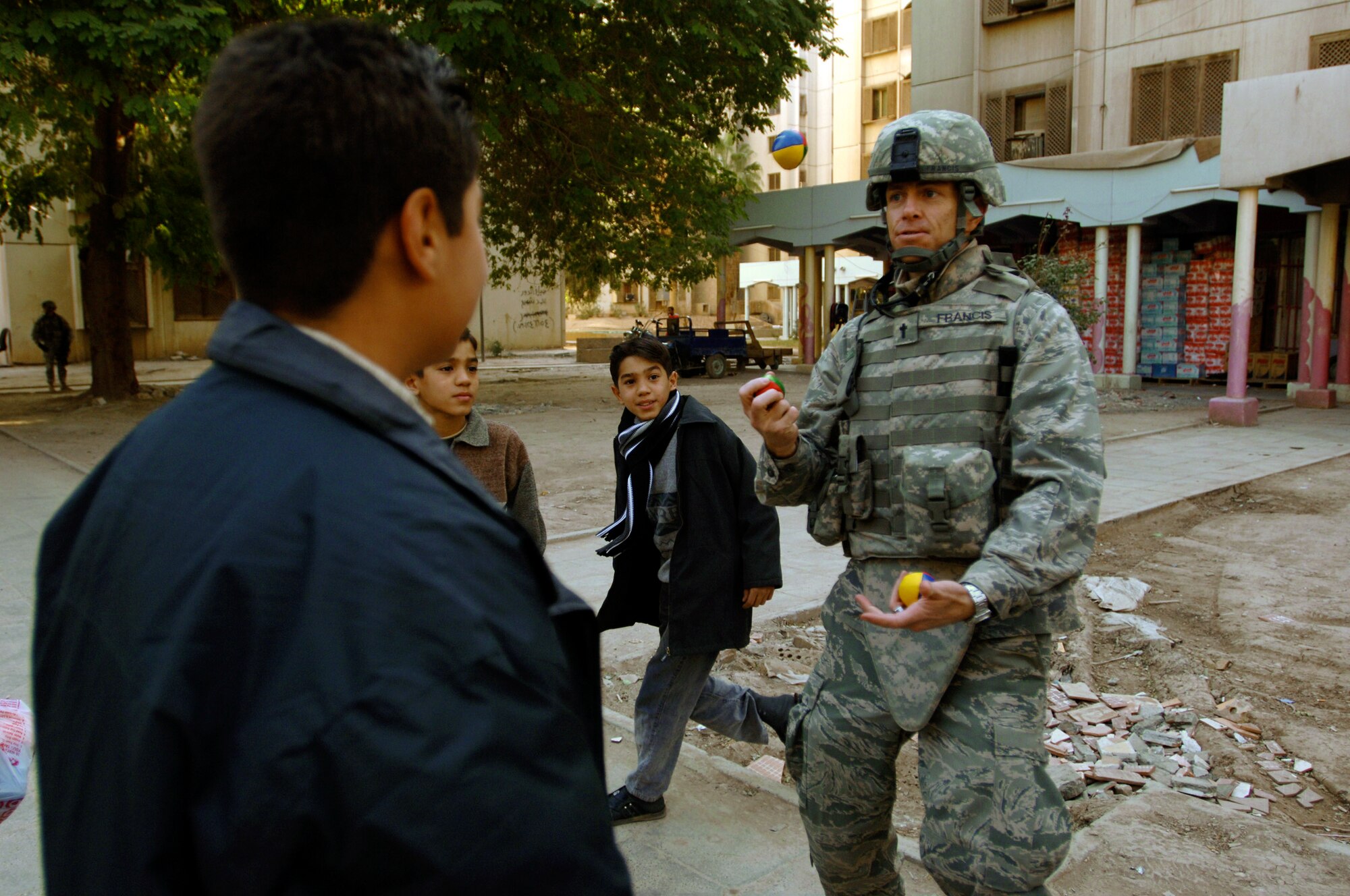 Chaplain (Capt.) Kelvin Francis entertains Iraqi children by juggling balls while on foot patrol in a apartment complex Jan. 10 in the International Zone in Baghdad, Iraq. Chaplain Francis is assigned to the 732nd Air Expeditionary Group Religious Support Team and deployed from Shaw Air Force Base, S.C. He is a native of Jacksonville, Fla. (U.S. Air Force photo/Tech. Sgt. Craig Lifton) 
