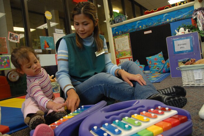 Madelyn Southall plays music with Sophia Ayala on a xylophone in the pre-toddler room at the Brig. Gen. Thomas R. Mikolajcik Child Development Center here Jan. 20.  The CDC recently eared national accreditation through the National Association for the Education of Young Children. Ms. Southall is a program assistant at the center and Sophia is the daughter of Tech. Sgt. Jose Ayala of the 437th Aircraft Maintenance Squadron.  (U.S. Air Force photo/Staff Sgt. Jennifer Arredondo)