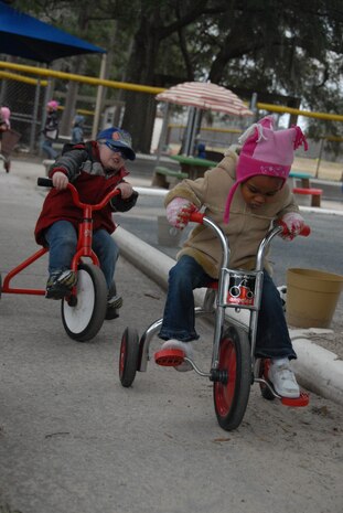 Children ride tricycles in a playground at the Brig. Gen. Thomas R. Mikolajcik Child Development Center here Jan. 20. The CDC recently earned national accreditation through the National Association for the Education of Young Children.  (U.S. Air Force photo/Staff Sgt. Jennifer Arredondo)