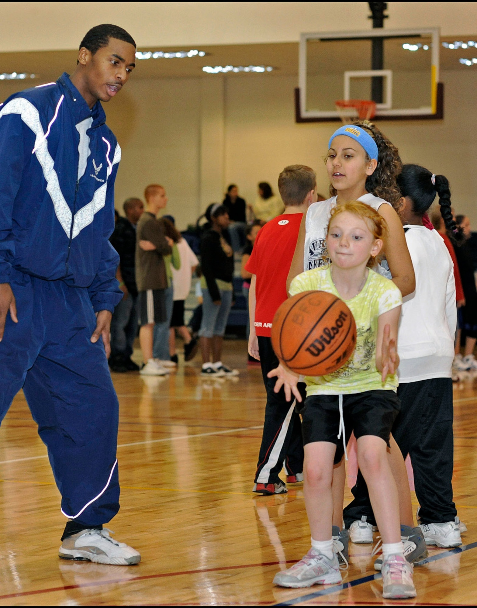 Airman 1st Class Jarrod Jemison teaches passing skills during a military youth basketball clinic Jan. 14 at the fitness center at Buckley Air Force Base, Colo. Shaquille O'Neal of the Phoenix Suns was a special guest for the clinic. Airman Jemison is assigned to the 460th Space Wing Public Affairs Office. (U.S. Air Force photo/Senior Airman Steven Czyz) 
