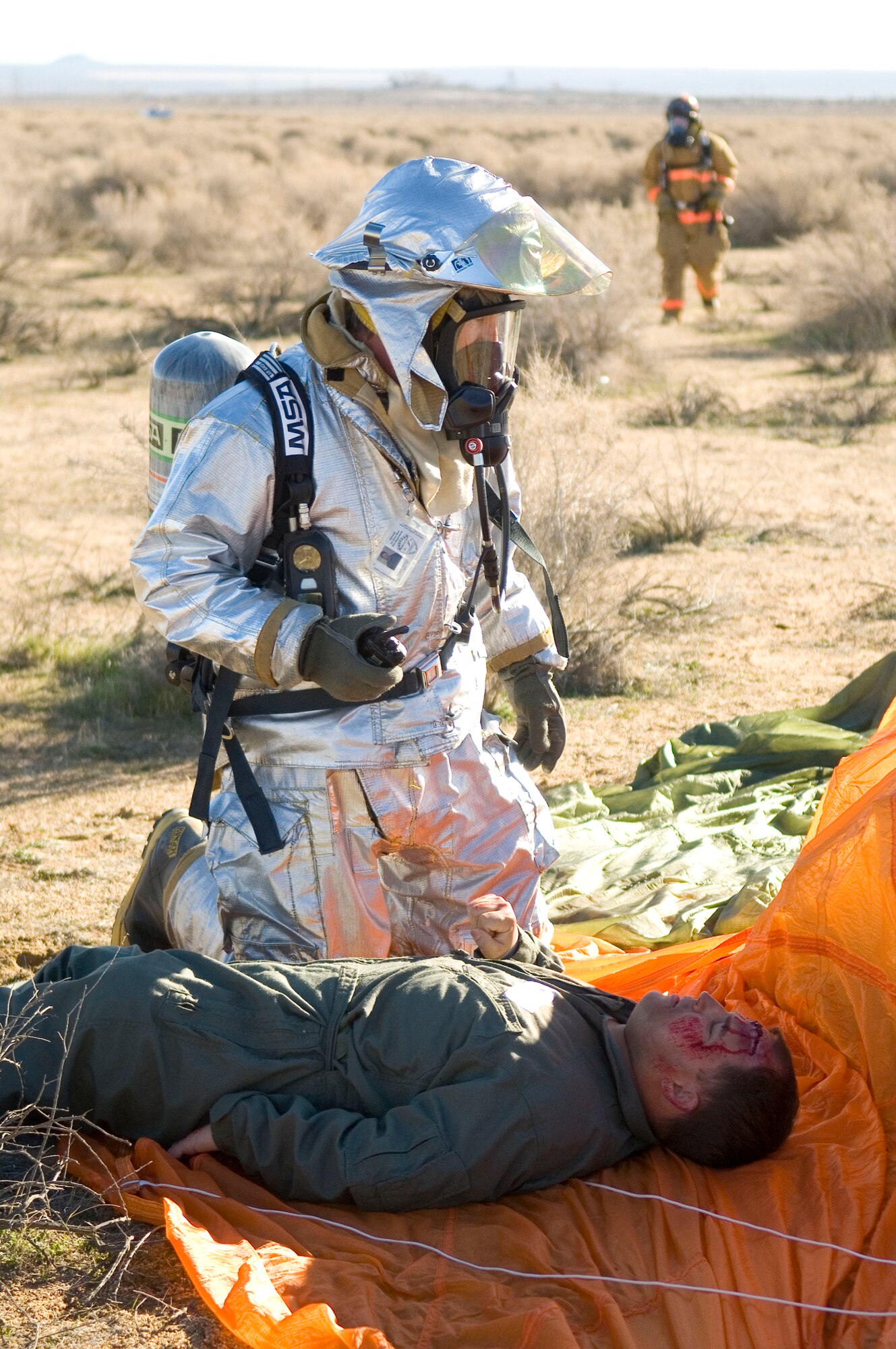 An Edwards firefighter assesses a survivor of a simulated F-16 Fighting Falcon crash at Camp Corum here Jan. 12 as part of the base's Unit Compliance Inspection. As part of the UCI, the Air Force Materiel Command Inspector General team looked at the base's common core compliance areas, which represent key processes, procedures and requirements based on by-law requirements, executive orders, Department of Defense directives and Air Force and AFMC instructions. (Air Force photo by Mike Cassidy)