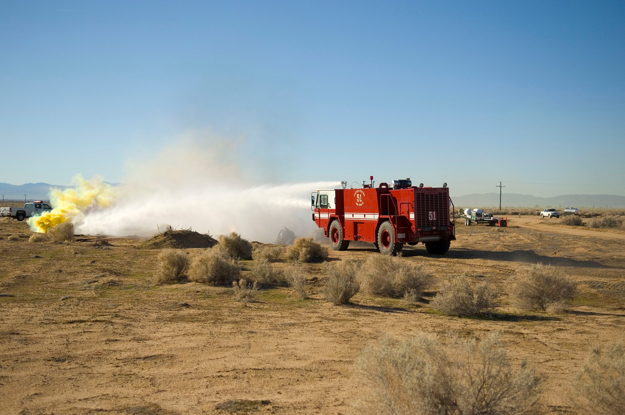 An Edwards fire truck extinguishes the "fire" caused by a simulated F-16 Fighting Falcon crash at Camp Corum Jan. 12. This is part of the base's Unit Compliance Inspection by the Air Force Materiel Command Inspector General. The IG also evaluated the base's four fundamental maintenance processes, including maintenance, technical data, tools and equipment, and qualification training, as part of Logistics Standardization and Evaluation Team inspection. (Air Force photo by Mike Cassidy)