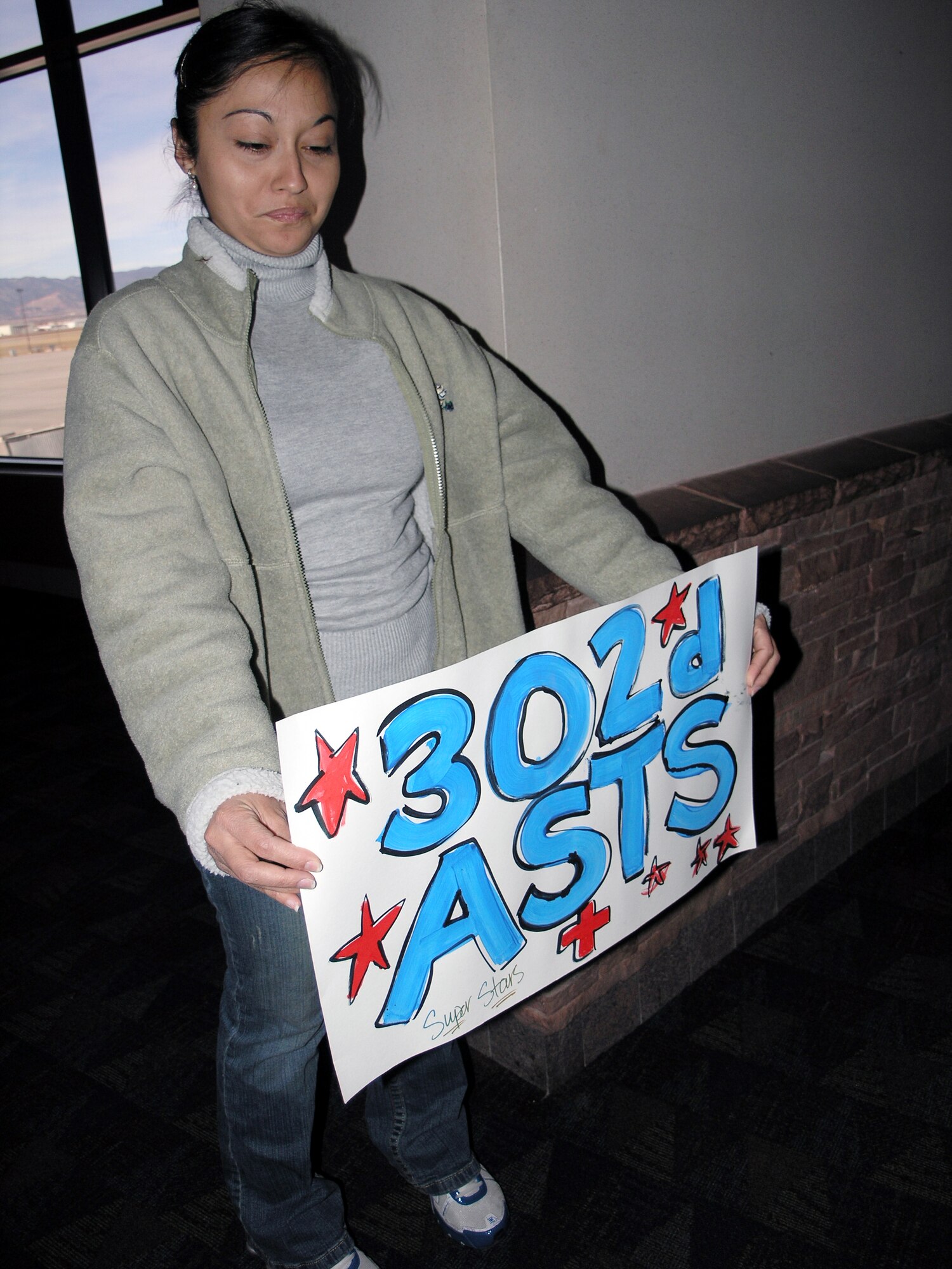 Rosa Le, 302nd Aeormedical Staging Squadron, holds a sign to welcome home ASTS members who had been serving at Balad Air Base, Iraq for the past four months.  (U.S. Air Force photo/Tech. Sgt. David D. Morton)