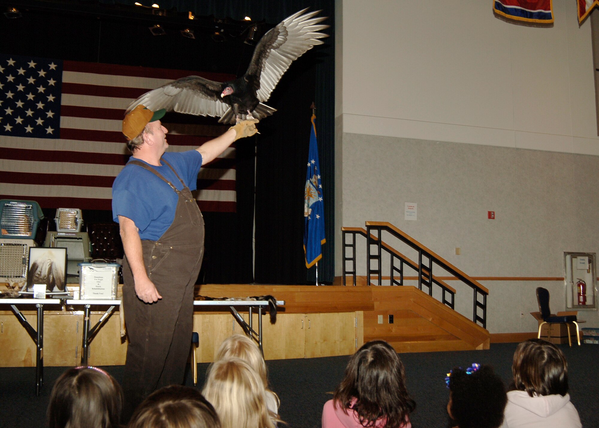 MCCONNELL AIR FORCE BASE, Kan. -- Ken Lockwood, program director of the Eagle Valley Raptor Center, lifts up “Herman Monster” the turkey vulture, for all Team McConnell members and their families to see during the family fun night at the Robert J. Dole Community Center, Jan. 16. During family fun night children were able to play games, touch various furs brought by Mr. Lockwood and learn about different birds of prey. (Photo by Airman 1st Class Maria Ruiz)