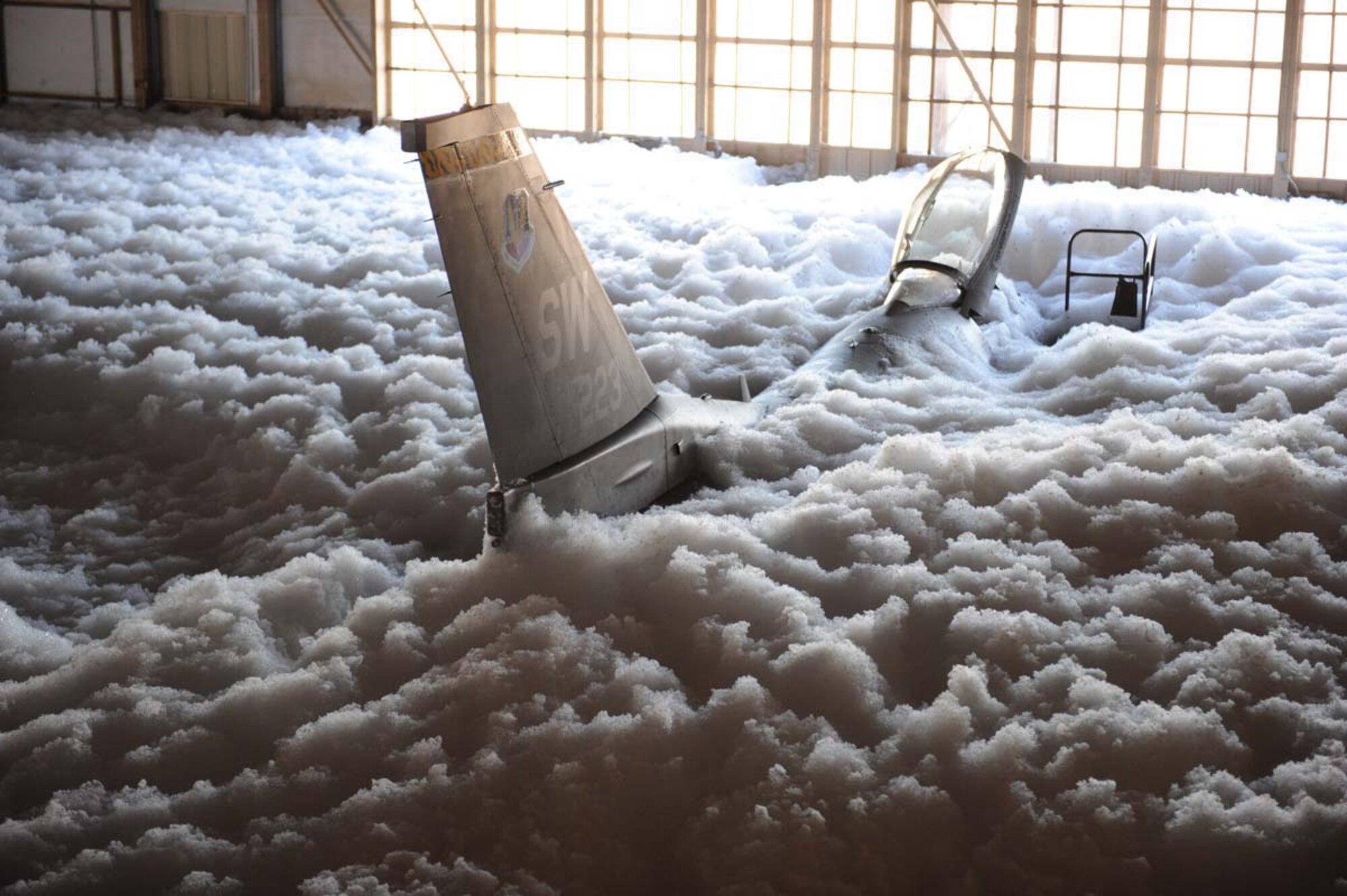 SHAW AIR FORCE BASE, S.C. -- An F-16 is submerged in foam after the fire surpression system in Hangar 1200 was activated Jan. 17. The quick response from Shaw's Airmen resulted in minimal damage to Air Force assets. (U.S. Air Force photo/SrA Matthew Davis) 