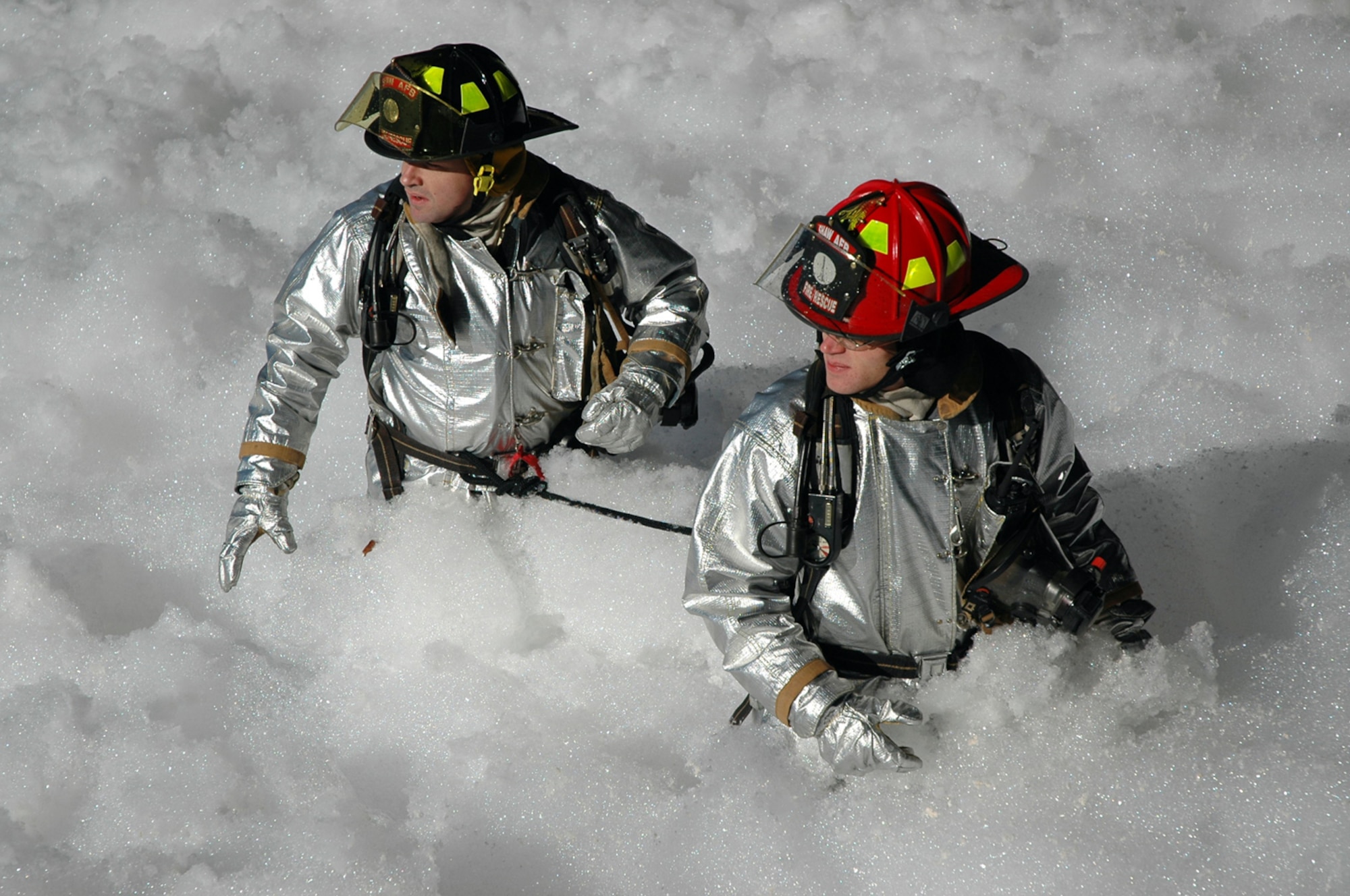 SHAW AIR FORCE BASE, S.C. -- (Lt.) Shayne Carder and Staff Sgt. Bradley McCroskey, 20th Civil Engineer Squadron firefighters, work their way through the foam in Hangar 1200 Jan. 17. the fire surpression system in the Hangar was activated Jan. 17. The quick response from Shaw's Airmen resulted in minimal damage to Air Force assets. (courtesy photo)