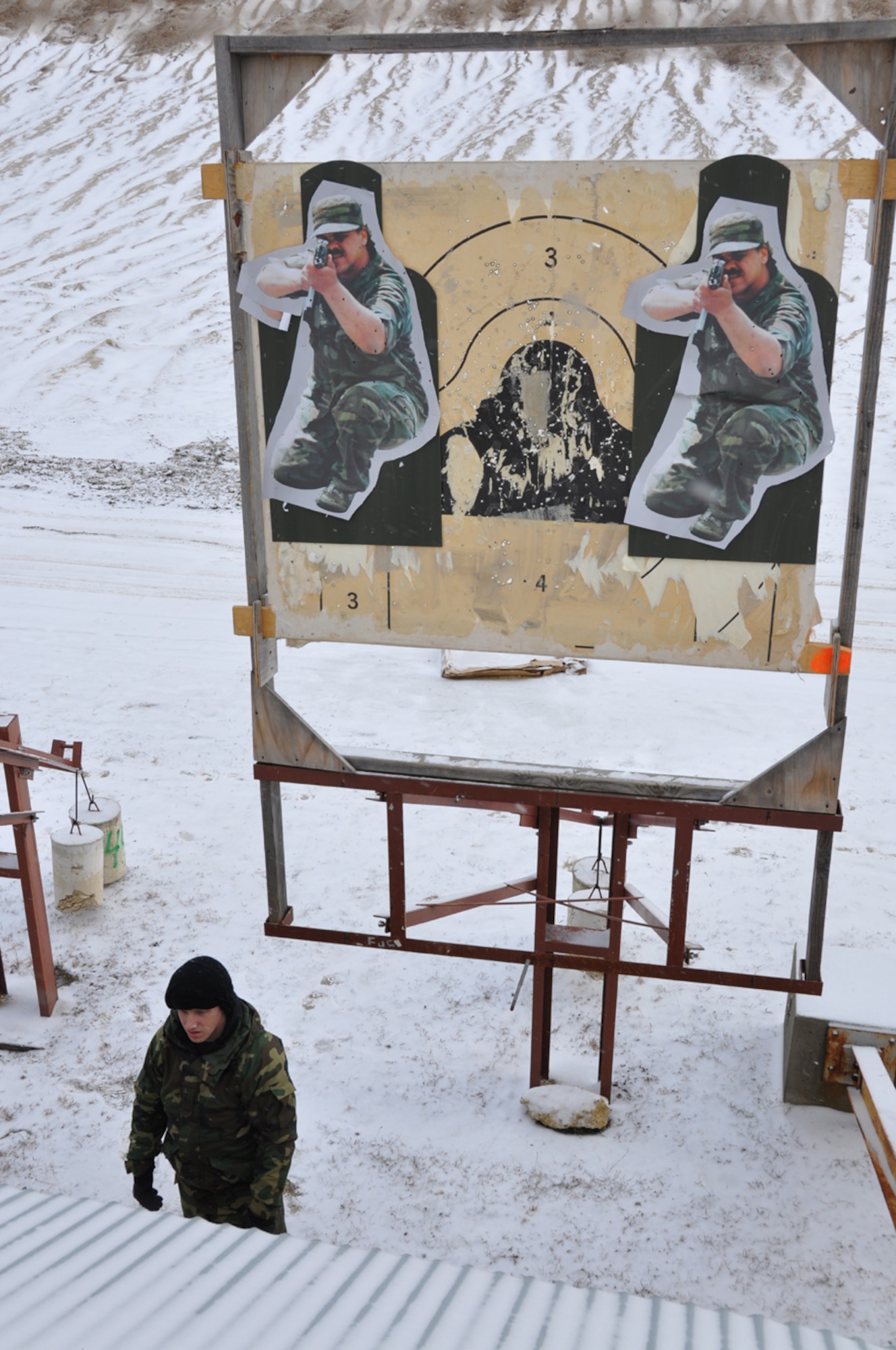 An Airman from the 818th Contingency Response Group prepares and operates pop-up targets for a live-fire exercise during the Defensive Operations Course held here Jan 12-15. The exercise incorporated firing the M-16 and M-9 at pop-up targets from the ranges of 100, 75, 50 and 25 meters. (U.S. Air Force photo/1Lt Dustin Doyle)