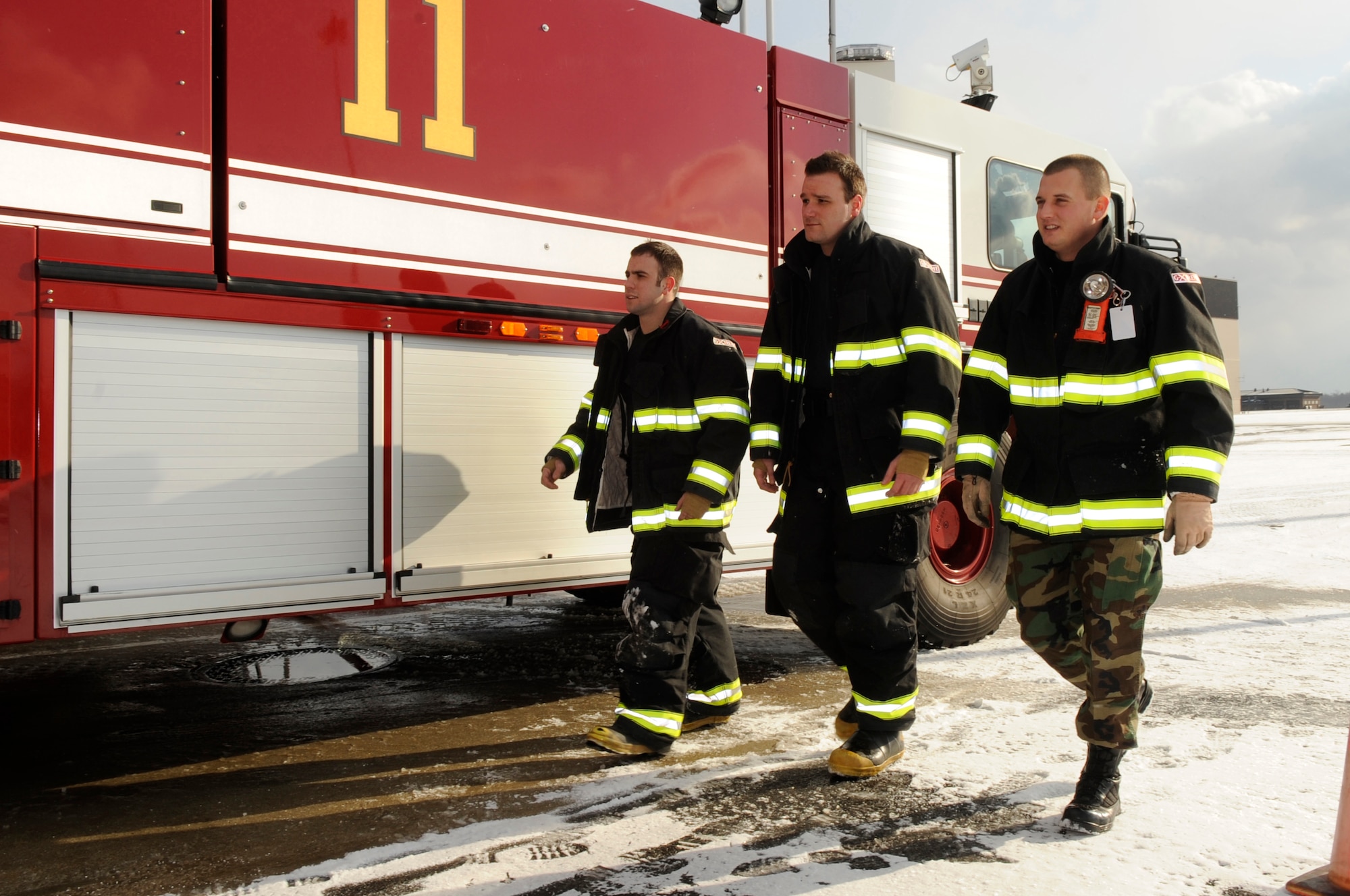 Right to left, After an egress training exercise Jan. 15, Staff Sgt. Thomas Cooper, 305th Civil Engineer Squadron crew chief, Senior Airman Jonathan Webb, 305th Civil Engineer Squadron driver/operator, and Senior Airman Andrew Douglas, 305th Civil Engineer Squadron driver/operator, walk back to the firehouse for a briefing to evaluate their performance. (U.S. Air Force photo/Carlos Cintron)
