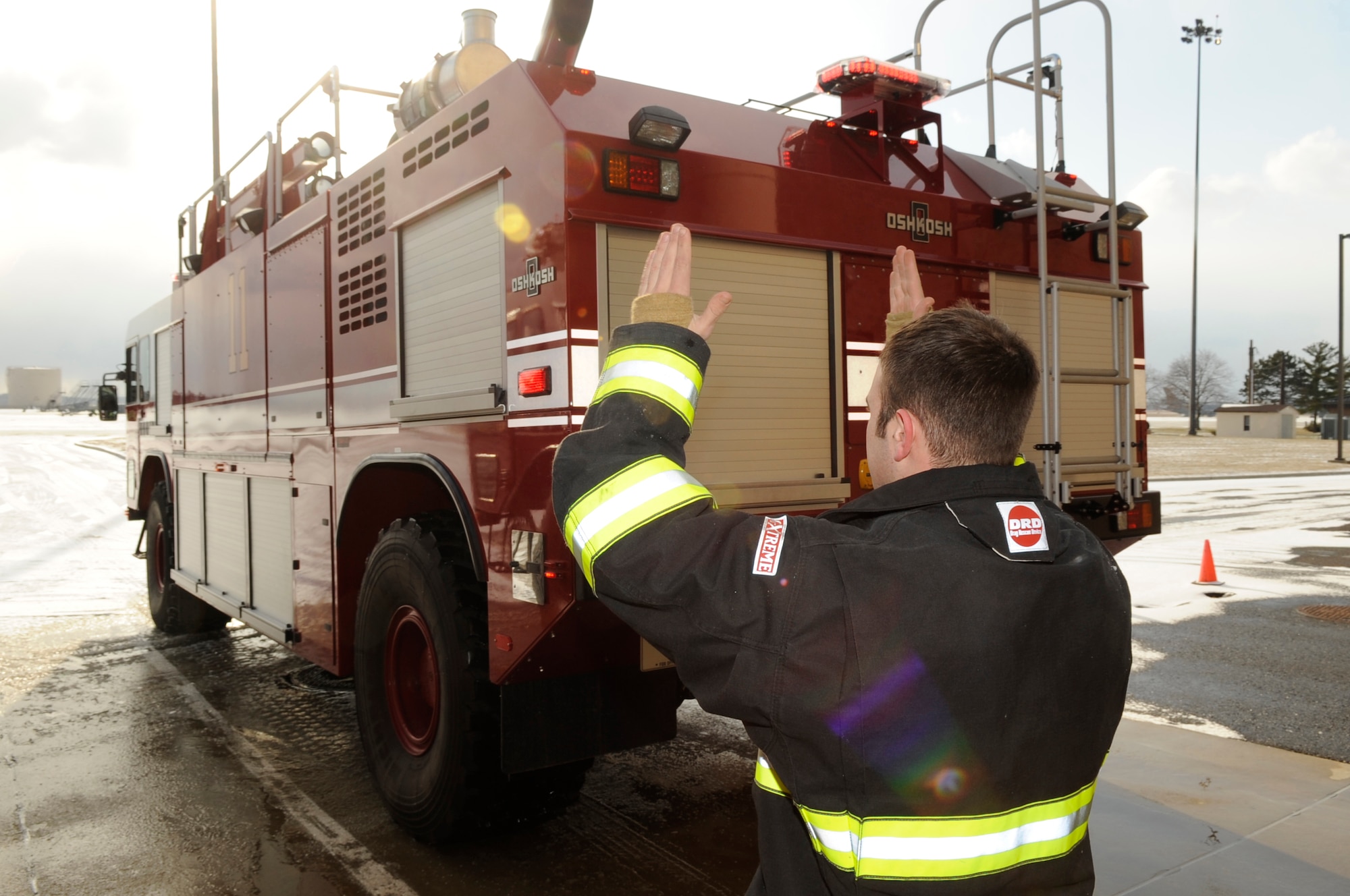 Once the egress training exercise is over, Senior Airman Andrew Douglas, 305th Civil Engineer Squadron driver/operator, helps the driver back the fire truck into the stall. The fire trucks are kept inside to prevent the water from freezing up during the cold winter months. (U.S. Air Force photo/Carlos Cintron)