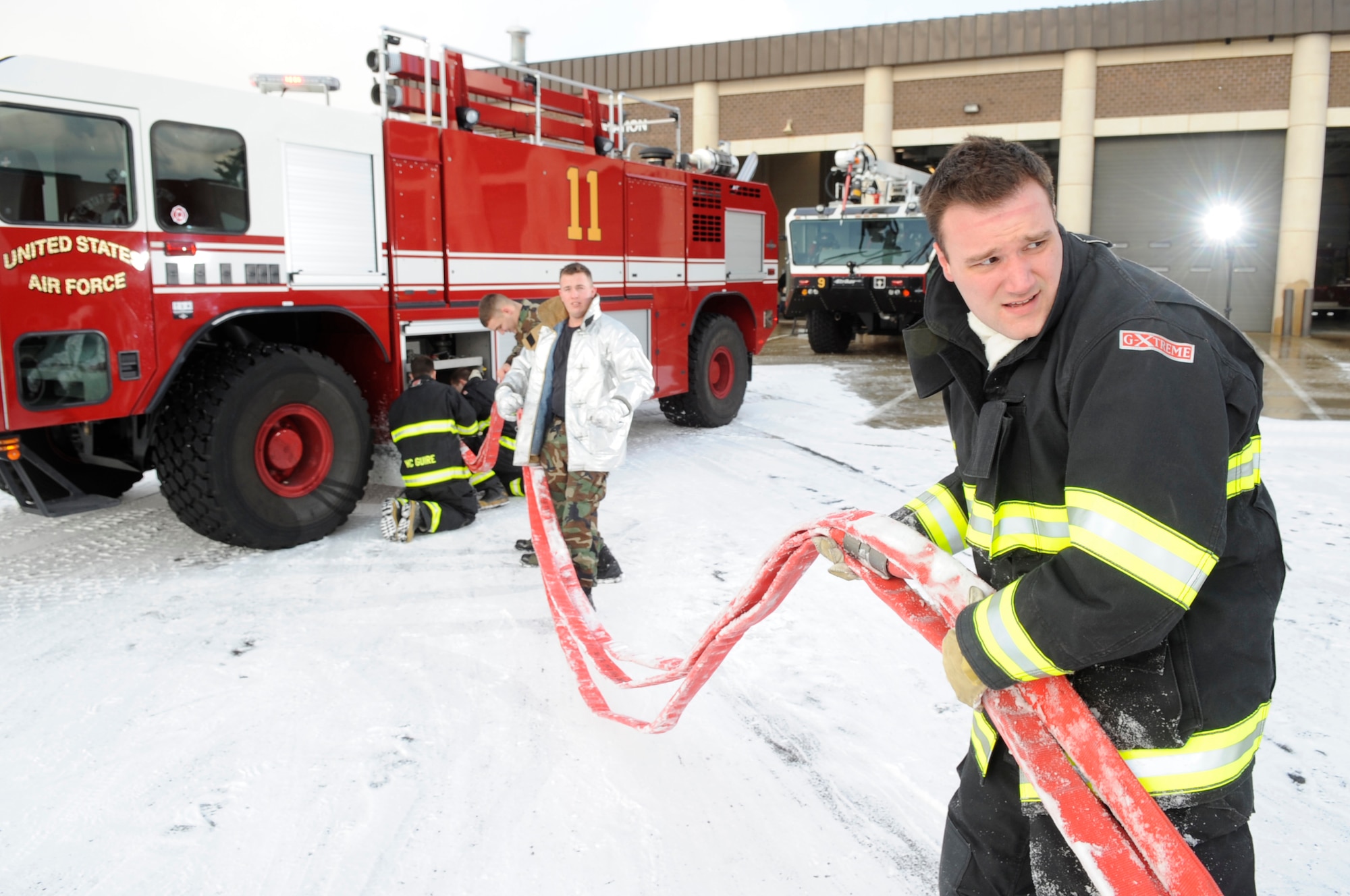 Senior Airman Jonathan Webb, 305th Civil Engineer Squadron driver/operator, helps repack the hose lines after the egress training exercise Jan. 15. The firefighters first use a triple fold, which reduces the length from 200 feet to 75 feet, and then fold the hose like an accordion to repack into the fire truck. (U.S. Air force photo/Carlos Cintron)