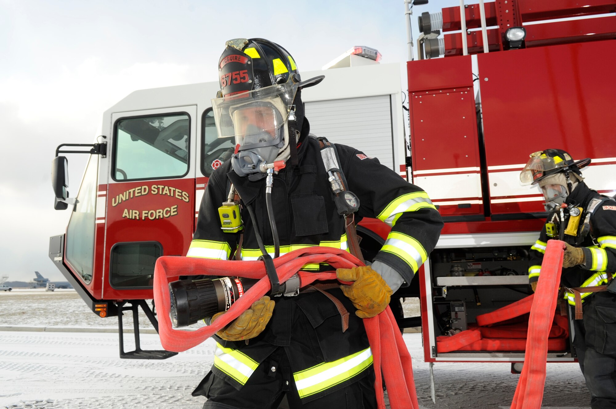 Senior Airman Jonathan Webb, 305th Civil Engineer Squadron driver/operator, advances the hose lines toward a KC-10 during an egress training exercise at the McGuire Fire Department Jan. 15. The hose line can be deployed up to 200 feet from the truck and the water pressure is 150 psi. (U.S. Air Force photo/Carlos Cintron)