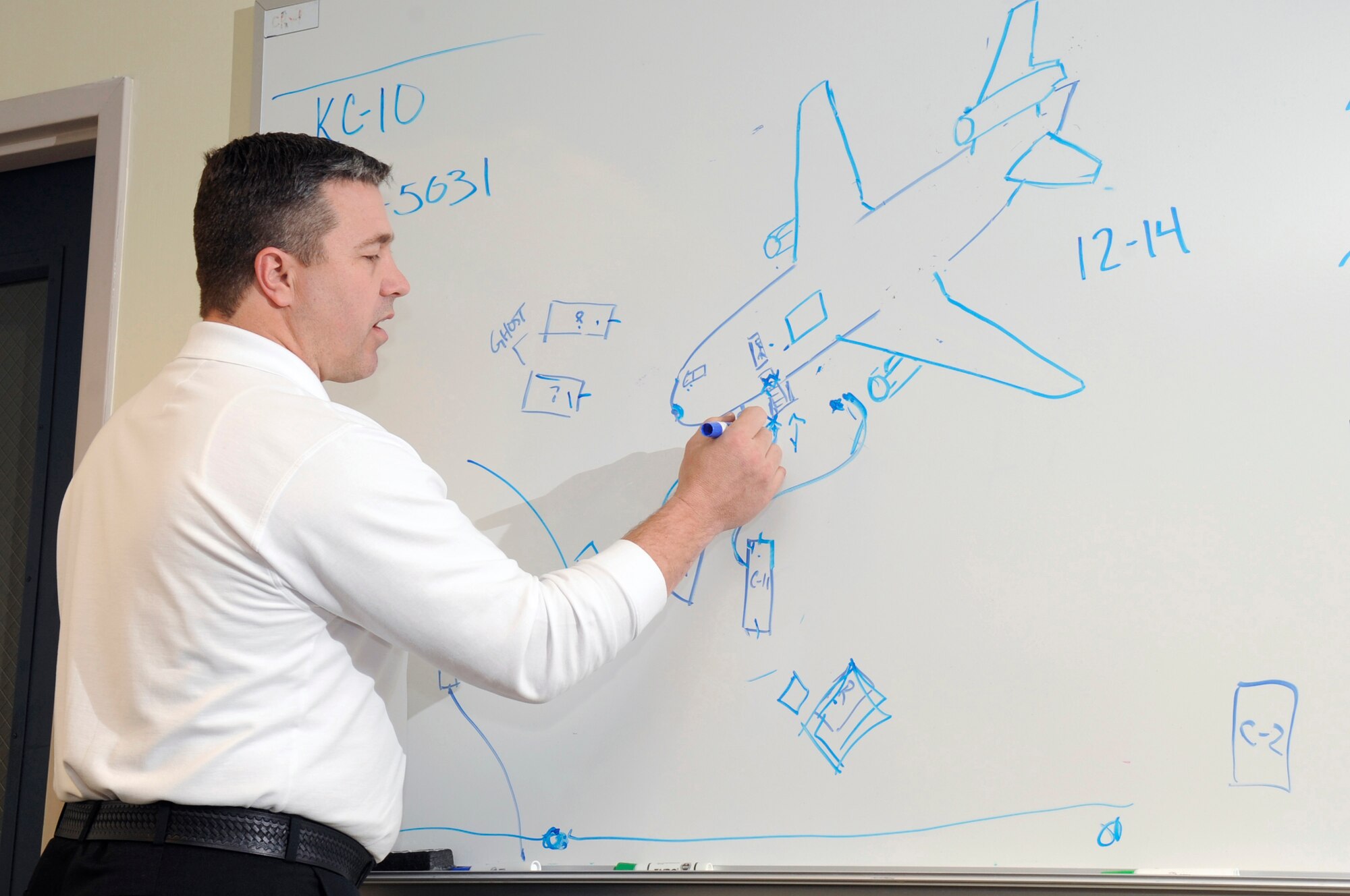 During a briefing for egress training, Dale Coder, McGuire Fire Department assistant chief of operations, draws a diagram of a KC-10 and the proper positioning of emergency vehicles and hose lines. The training exercise simulates a KC-10 fire and how to quickly extinguish and rescue the crew. (U.S. Air Force photo/Carlos Cintron) 
