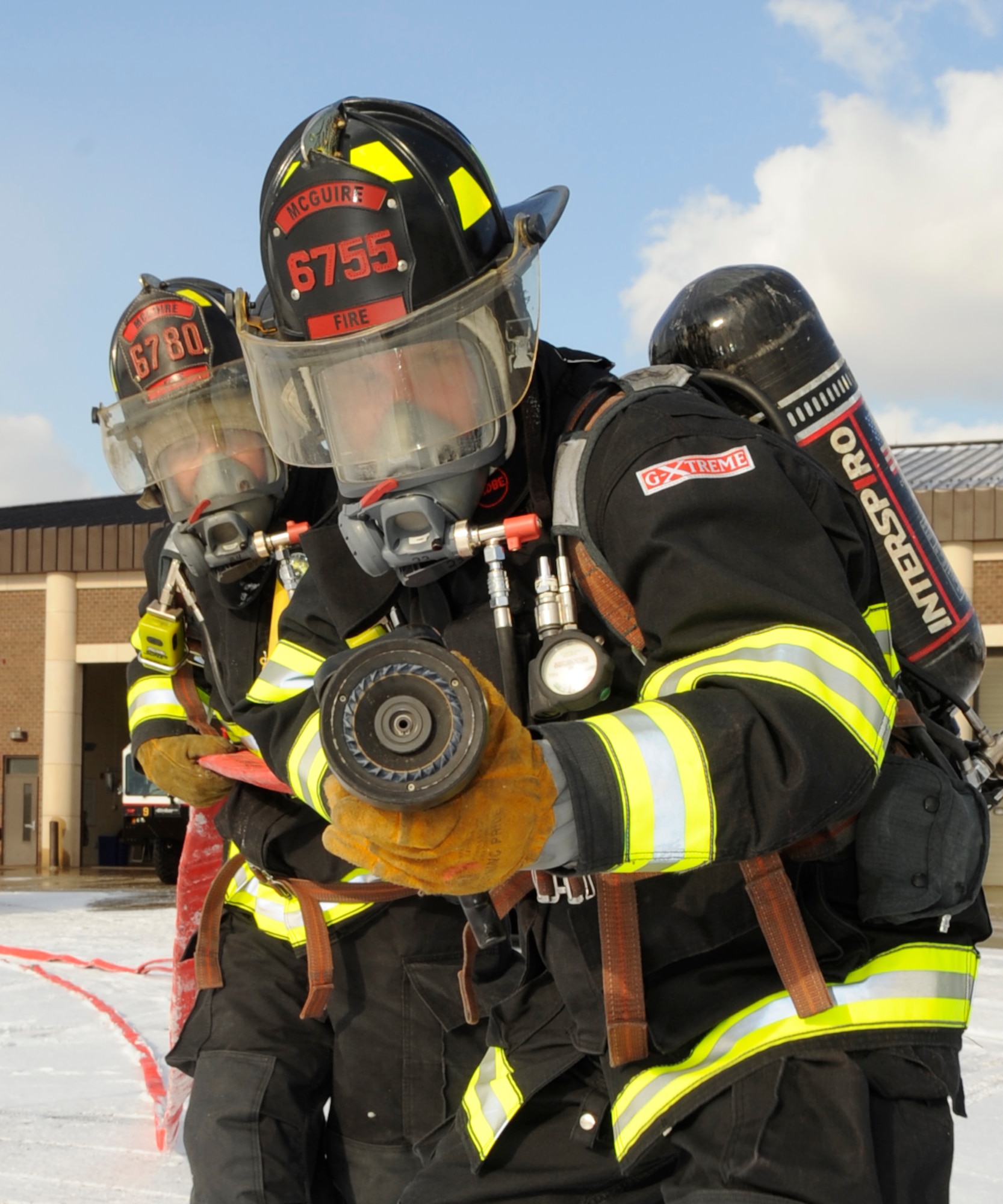 Right, Senior Airman Jonathan Webb, 305th Civil Engineer Squadron driver/operator, and Senior Airman Corey Burd, 305th CES driver/operator, practice firefighting tactics during egress training exercises Jan. 15. McGuire’s Fire Department conducts these exercises at least once every month in order to stay current and to be ready for any emergency situation that may occur. (U.S. Air Force photo/Carlos Cintron)     