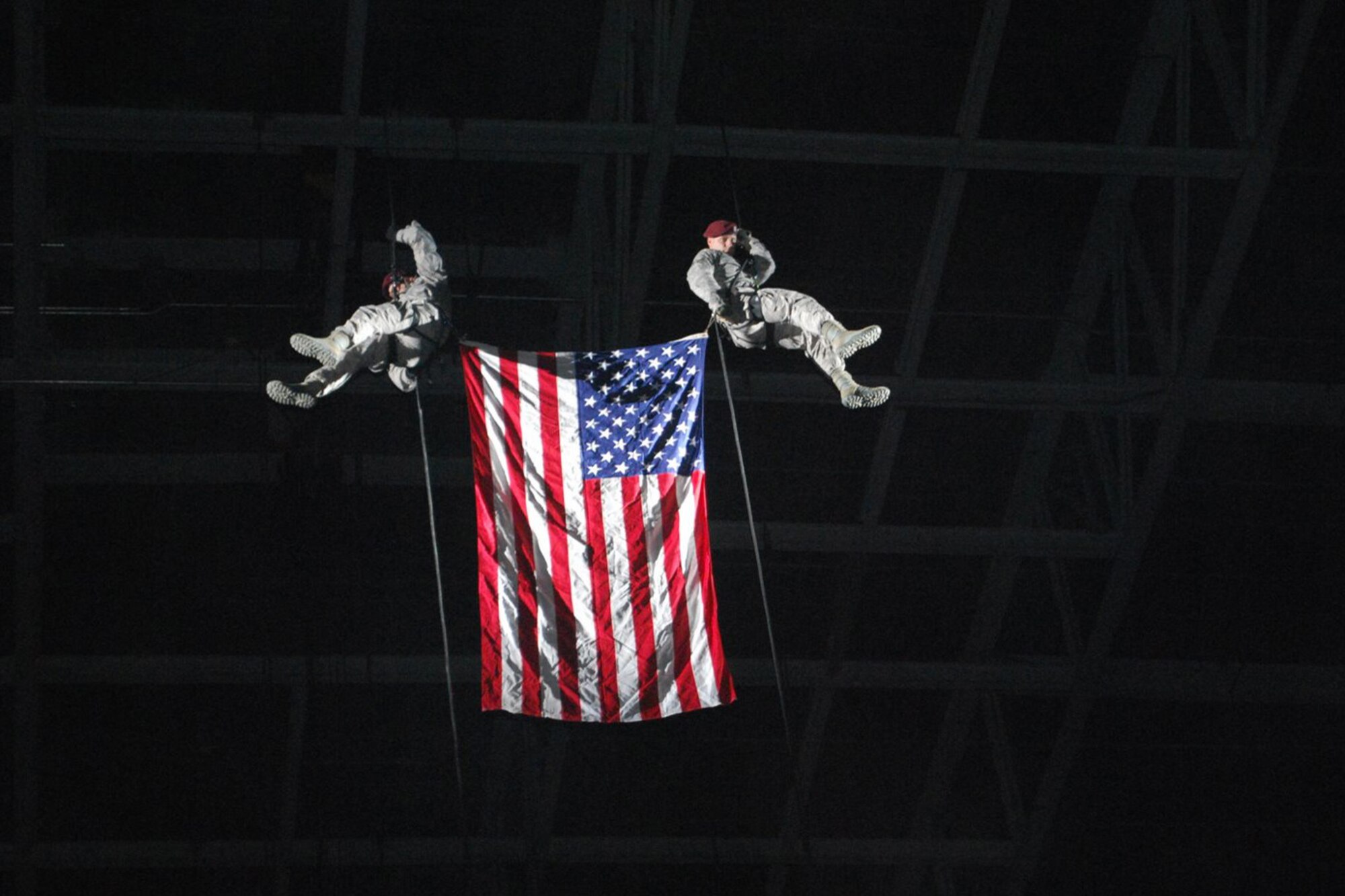 Master Sgt. Robbie Bean and Senior Airman John Ostrowske, Air Force Pararescuemen from Wright Patterson Air Force Base, rappel from the roof of the Ervin J. Nutter Center with the American flag during the opening ceremony of an Arenacross 2009 series race event. Air Force career opportunities were spotlighted during the Jan. 17 dirt bike race, held on the Wright State University campus. (U.S. Air Force photo/Tech. Sgt. Libby Stevenson) 