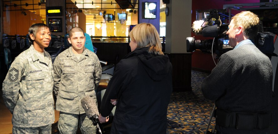 Senior Master Sgt. Loretta Glasgow and Staff Sgt. Greg Posada both from the 100th Force Support Squadron, are interviewed by a local television station reporter about their views of the United States' newest President, Barack Obama, at the Galaxy Club Jan. 20, 2009, at RAF Mildenhall, England. (U.S. Air Force photo by Staff Sgt. Jerry Fleshman)