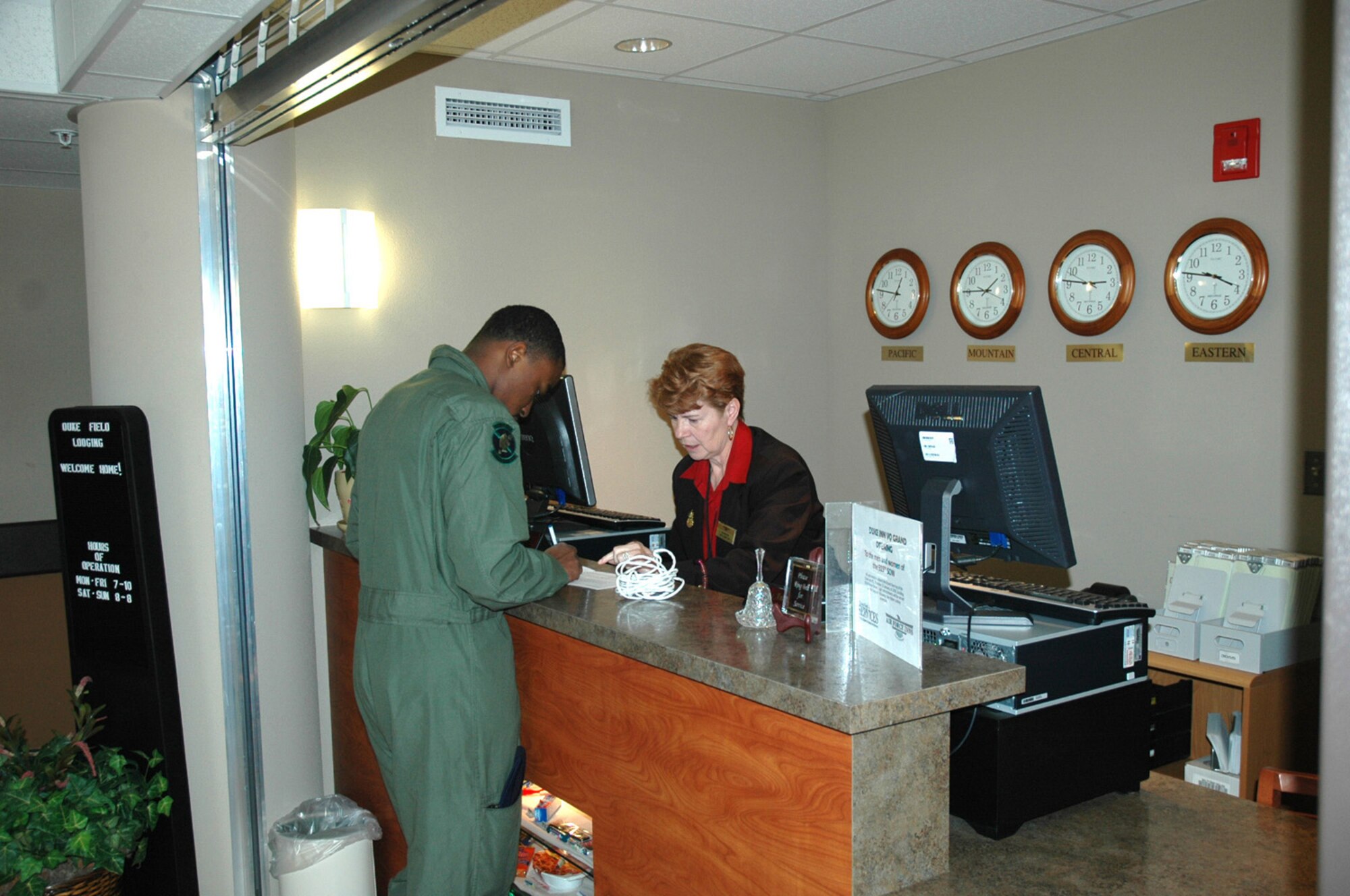 Bea Anderson, 919th Services Flight, helps a guest at the lobby front desk of the newly re-opened Duke Inn Visiting Quarters. The three-story lodging facility officially re-opened Thursday after an 18-month, $5.6 million renovation project brought state-of-the-art amenities to a facility that for years failed to meet Air Force lodging standards. The renovation, funded by Air Force Reserve Command, features 48 private rooms with full baths, queen-size beds, two handicapped-accessible rooms, a guest elevator and a lobby business center with computer access, a beverage bar and numerous other amenities. (U.S. Air Force Photo by Daniel Neely)