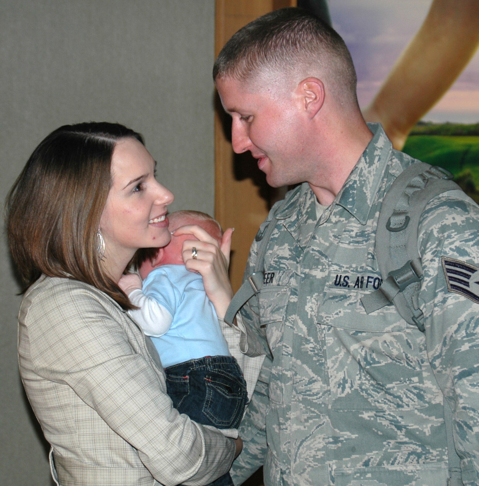 Staff Sgt. Joseph Speer, a reservist assigned to the 81st Aerial Port Squadron at Charleston Air Force Base, S.C., shares a tender moment with his wife, Elizabeth and meets his son, Joseph Jr., for the first time on Jan. 17, 2009. Sergeant Speer's son was born while he was deployed to Afghanistan for four months. The sergeant and 17 other Airmen from the 81st and 38th Aerial Port Squadrons returned home the same day. (U.S. Air Force photo/Capt. Wayne Capps)