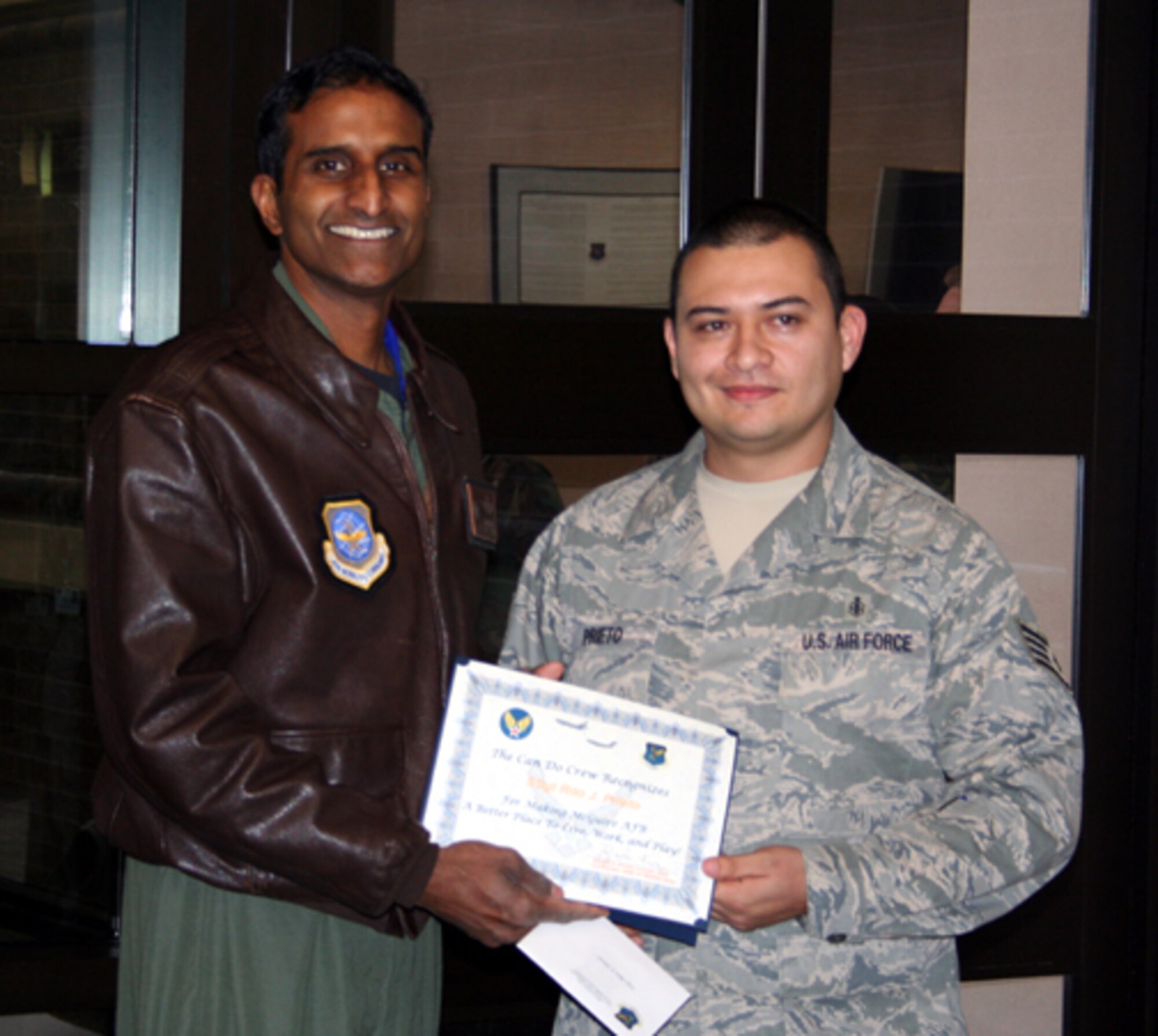 Left, Col. Balan Ayyar, 305th Air Mobility Wing commander, presents a Can Do Crew award to Staff Sgt. Rito Prieto, with the 305th Aeromedical Squadron assigned to the 2nd Air Refueling Squadron. His nomination is below. 

“Sergeant Prieto is one of those ‘Can Do’ Team McGuire members behind the
scenes. He is our wing's first non-Security Forces Combat Skills instructor. He volunteered more than 850 hours conducting training for deploying Airmen, ensuring basic contingency skills for weapon handling and self-defense. He is the first IDMT in the Air Force to be certified by the USA in the Modern Army Combatives Program as an instructor, and he's implemented Air Mobility Command's first Tactical First Aid/Advanced Combat Buddy Care Training Plan, incorporating both classroom instruction and comprehensive evaluations at the USA's Combat Life Saver Litter Obstacle Course. He has seen more than 300 patients in the clinic in the last two years; the requirements for maintaining his skills are 48 patients per year. He is always the first to volunteer to staff other areas and has been a team player with Deployment Medicine and Immunizations when coverage was needed.  Sergeant Prieto also taught triage control for Team McGuire's 2008 Air Show for medical, Cub Scouts and ROTC members. He is well known as the one to go to; he was handpicked to provide austere field medical coverage at Sea Grit in support of joint Survival, Evasion, Resistance, and Escape and Coast Guard operations. His dedication to other Airmen is shown in his willingness to initiate a voluntary comprehensive PT program for interested Air Force personnel with a class now up to 14 members with no PT test failures.

Be aware that the "Can Do Crew" is everywhere, looking for outstanding service. They covertly seek members of Team McGuire who make a difference, identifying and recognizing only the best! Remember, the strongest asset of Team McGuire is its people; you are what makes McGuire a better place to li