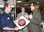 Terrye Heagerty (right), 12th Services Division director, presents an all-expense paid trip to the Super Bowl to Geoff Morgan, an Air Force Services club member who works at the Randolph Bowling Center, Jan. 9. As winner of Services' Football Frenzy program, Mr. Morgan will receive airfare, hotel and vehicle accommodations for two and tickets to the game. (Courtesy photo)
