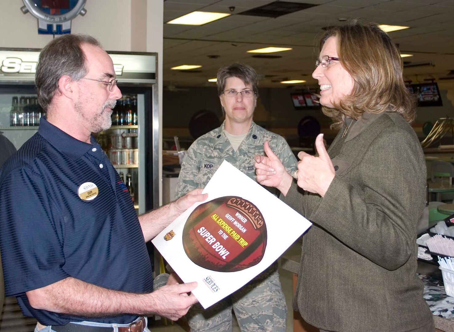 Terrye Heagerty (right), 12th Services Division director, presents an all-expense paid trip to the Super Bowl to Geoff Morgan, an Air Force Services club member who works at the Randolph Bowling Center, Jan. 9. As winner of Services' Football Frenzy program, Mr. Morgan will receive airfare, hotel and vehicle accommodations for two and tickets to the game. (Courtesy photo)