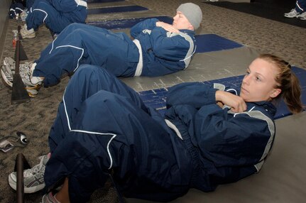 Lauren Wilson and Colt Brock kick off the 100 Days of Push-ups and Sit-ups Commander's Fitness Challenge during their morning physical training session at the base fitness center Jan. 20. The challenge is a base-wide event for teams of 10 to complete 100,000 push-ups and sit-ups in 100 days. Wilson and Brock are assigned to the 437th Contracting Squadron. (U.S. Air Force photo/Staff Sgt. Marie Cassetty)