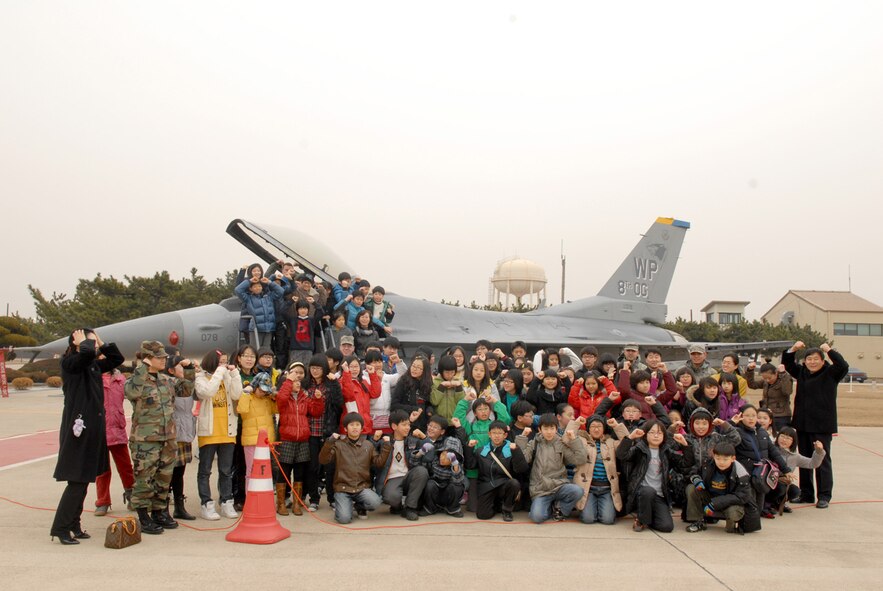 A group of Korean elementary school students, pose in front of an F-16 at Kunsan Air Base, Republic of Korea, Jan 21, 2008. The tour is part of the Good Neighbor Program that aims to enhance therelationship between the local community and Airmen assigned to Kunsan.(US Air Force Photo By Senior Airman Angela Ruiz)
 