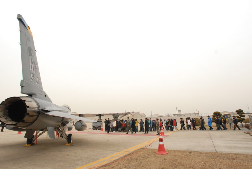 A group of Korean elementary school students, crowd around an F-16 at Kunsan Air Base, Republic of Korea, Jan 21, 2008. The tour is part of the Good Neighbor Program that aims to enhance the relationship between the local community and Airmen assigned to Kunsan.(US Air Force Photo By Senior Airman Angela Ruiz)

