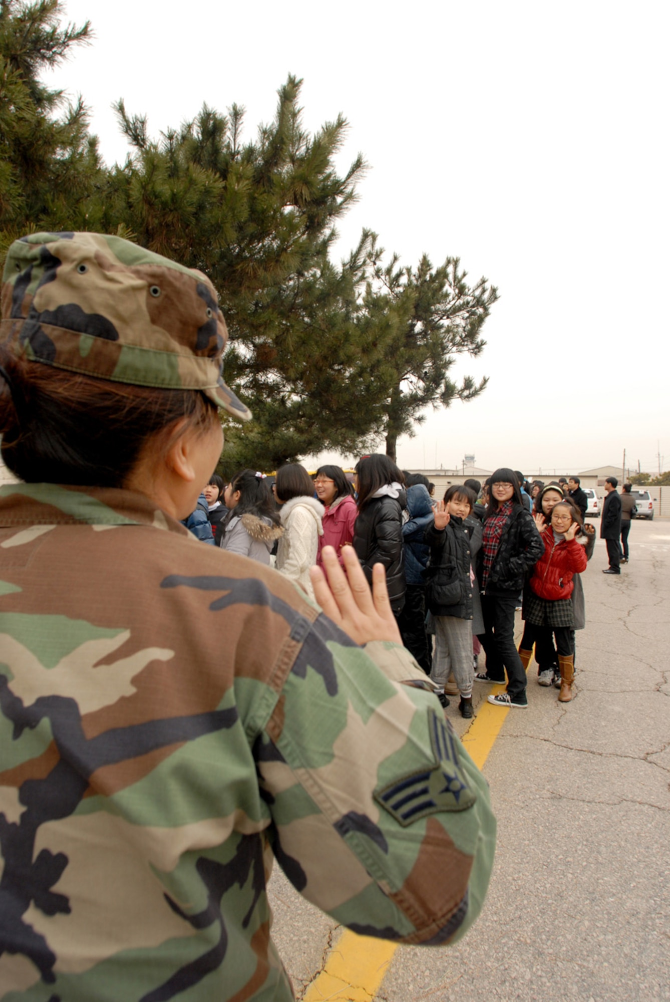 Senior Airman Leah Martin, 8th Force Support Squadron, welcomes a group of Korean elementary school students during a base tour, at Kunsan Air Base, Republic of Korea, Jan 21, 2008. The tour is part of the Good Neighbor Program that aims to enhance the relationship between the local community and Airmen assigned to Kunsan.(US Air Force Photo By Senior Airman Angela Ruiz)
