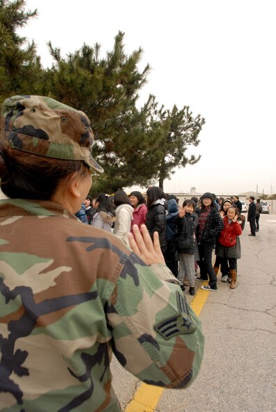 Senior Airman Leah Martin, 8th Force Support Squadron, welcomes a group of Korean elementary school students during a base tour, at Kunsan Air Base, Republic of Korea, Jan 21, 2008. The tour is part of the Good Neighbor Program that aims to enhance the relationship between the local community and Airmen assigned to Kunsan.(US Air Force Photo By Senior Airman Angela Ruiz)
