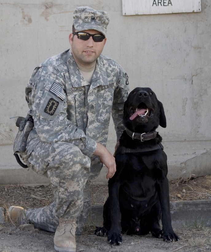 Army Sgt. Jess Storie, a dog handler, and his “battle buddy” Jose, a Labrador retriever, take a break following an afternoon training session in explosives search on Camp Slayer, Iraq, Jan. 16, 2009. The dog and handler are one of only seven dog teams that support Baghdad and the outlying province. U.S. Army photo by Staff Sgt. Brock Jones