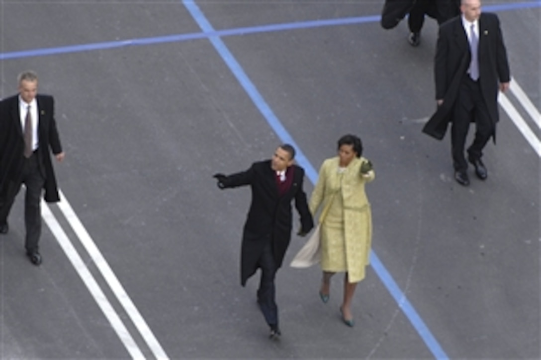 President Barack Obama and first lady Michelle Obama wave to the crowd as they make their way down Pennsylvania Avenue during the 2009 presidential inaugural parade in Washington, D.C., Jan. 20, 2009.  More than 5,000 men and women in uniform are providing military ceremonial support to the presidential inauguration, a tradition dating back to George Washington's 1789 inauguration.
