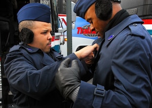 Chief Master Sgt. Verdell Nash, 113th Mission Support Flight superintendent, left, helps button Master Sgt. Mark Ward’s, 113th Logistics Readiness Squadron refueling mechanic, right, all weather coat before marching in the inuaguration parade. (Official U.S. Air Force photo by Tech. Sgt. Adrianne Wilson )