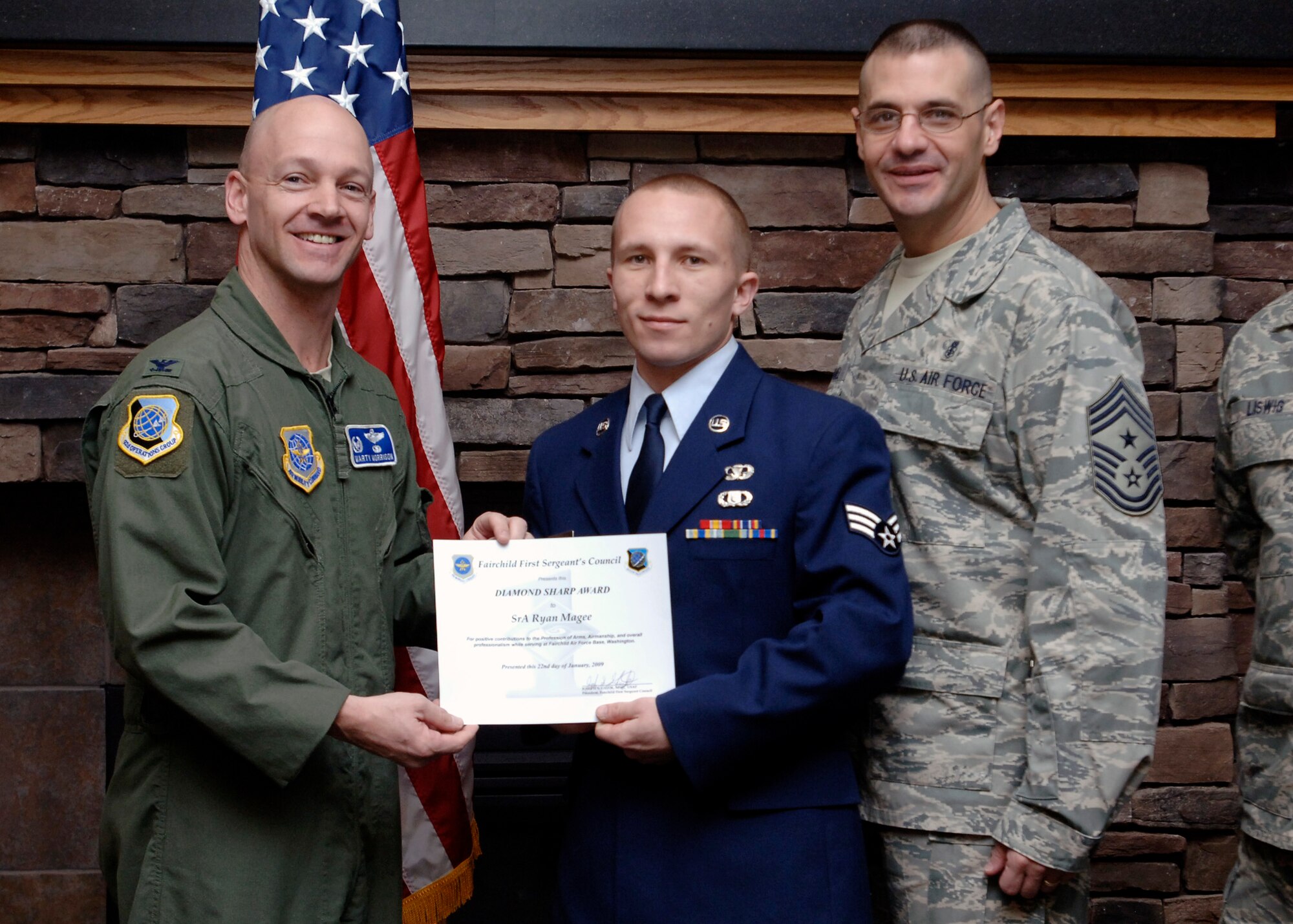 FAIRCHILD AIR FORCE BASE, Wash. –– Col. Marshal Morrison, 92nd Operations Group commander, and Chief Master Sgt. David Nordel, 92nd Air Refueling Wing command chief, present Senior Airman Ryan Magee, 66th Training Squadron Survival, Evasion, Resistance Escape cadre, with the Diamond Sharp award at the Warrior Dinning Facility Jan. 22. Master Sgt. Kyle Liswig, 66th Training Squadron first sergeant, nominated Airman Magee for his outstanding job performance and “fulfilling job requirements a [technical] sergeant or master sergeant would do but with airman first class pay”. (U.S. Air Force photo / Airman 1st Class Melissa L. Barnett)