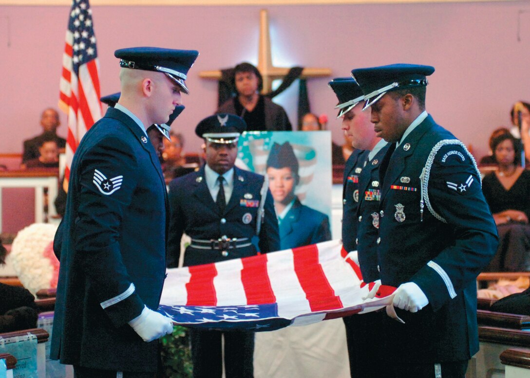 The Andrews Honor Guard hold the United States flag at a ‘flat top’ position during the flag folding ceremony portion of the military funeral honors as Master Sgt. Timothy Molock, center, observes.  (Official U.S. Air Force photo by Bobby Jones)