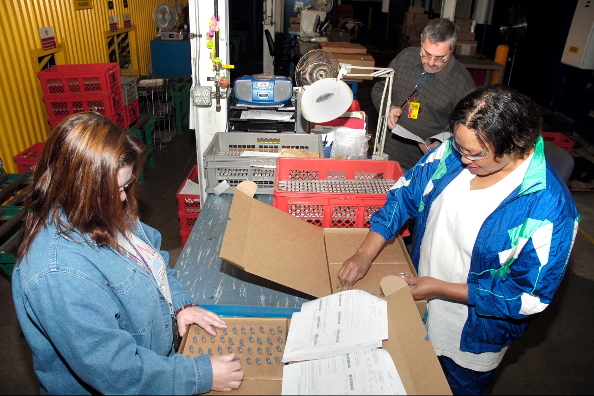 Gary Richards, Clara Norwood, right, and Verla Brown assemble parts in the F100 weigh-in area for compressor blade kits. (Air Force photo/Kelly White)