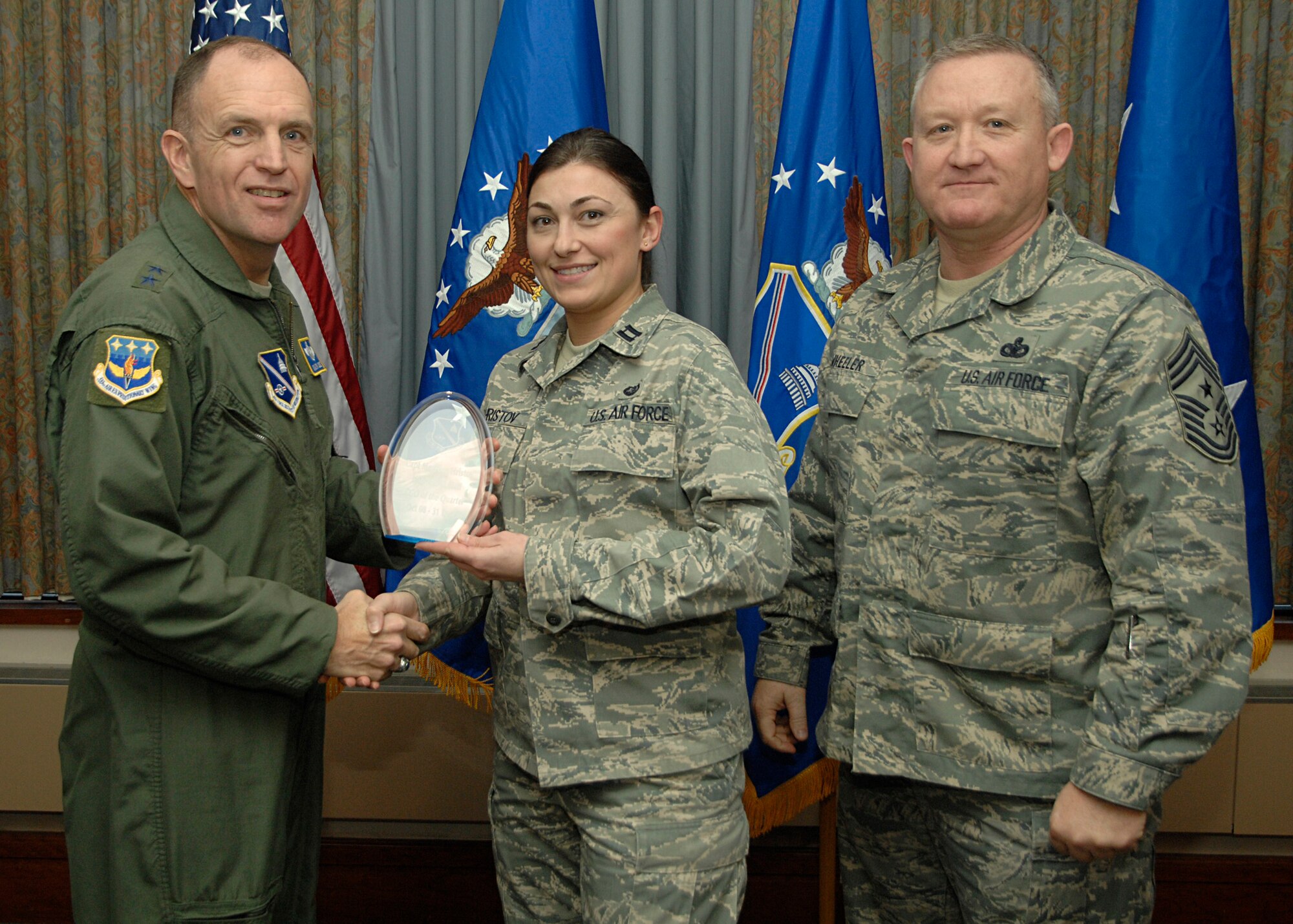 Capt. Meglena Hristov accepts the award for "Best CGO of the Quarter" from Air Force District of Washington Commander, Maj. Gen. Ralph Jodice, and AFDW Command Chief, Chief Master Sgt. Paul Wheeler, during the AFDW Quarterly Awards Ceremony, held Jan. 22 at the Andrews Air Force Base club. Captain Hristov works in the AFDW Legal Office. 