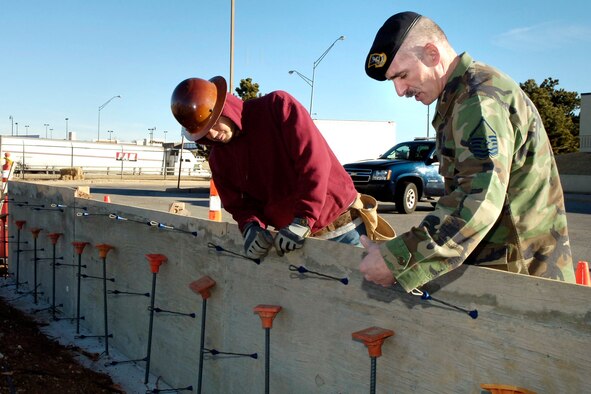 Master Sgt. Pete Way, 72nd Security Forces Squadron security installation superintendent, discusses specifications with Jacob Shirey of Red Dirt Concrete while working on an Anti-Terrorism Force Protection Upgrade Project near Bldg. 591. Sergeant Way won the Air Force Col. Billy Jack Carter award. (Air Force photo by Kelly White)